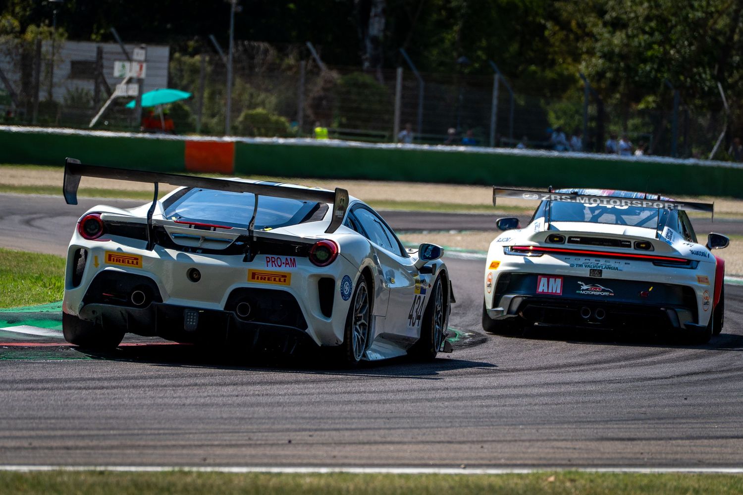 Two GT3 cars run closely together through a corner at Imola.