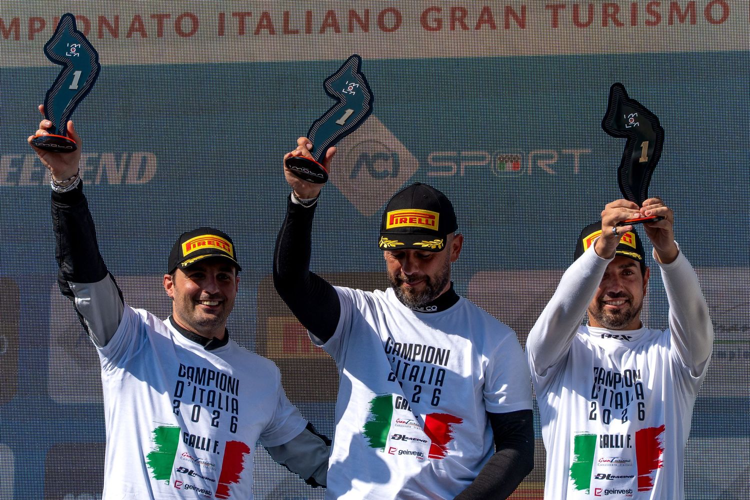 Three CIGT Endurance drivers celebrating on the podium with trophies raised.