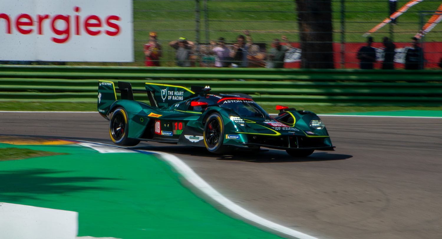 Green Aston Martin endurance Hypercar driving through a corner at Imola circuit.