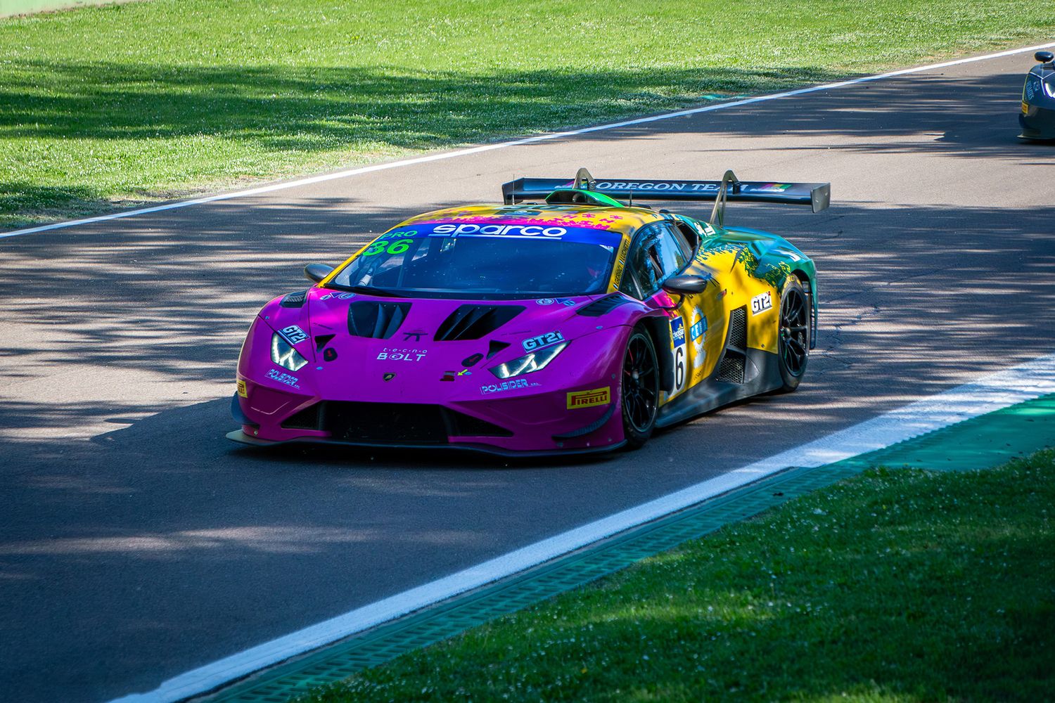 Purple, yellow and green Lamborghini GT3 car racing on the track at Imola during ACI Racing Weekend.