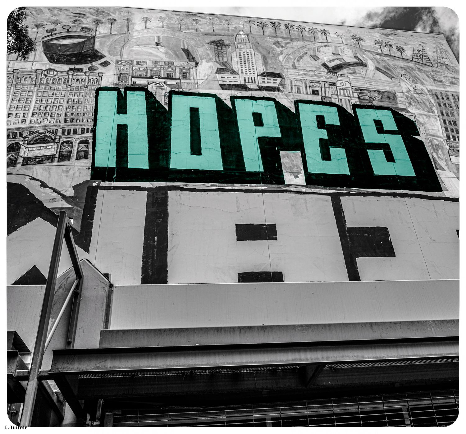 Colorful green HOPES sign on urban building facade in selective color.