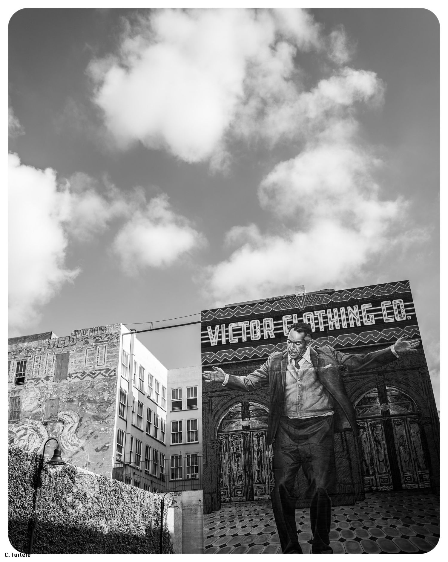 Black and white mural of man with outstretched arms at Victor Clothing Co.