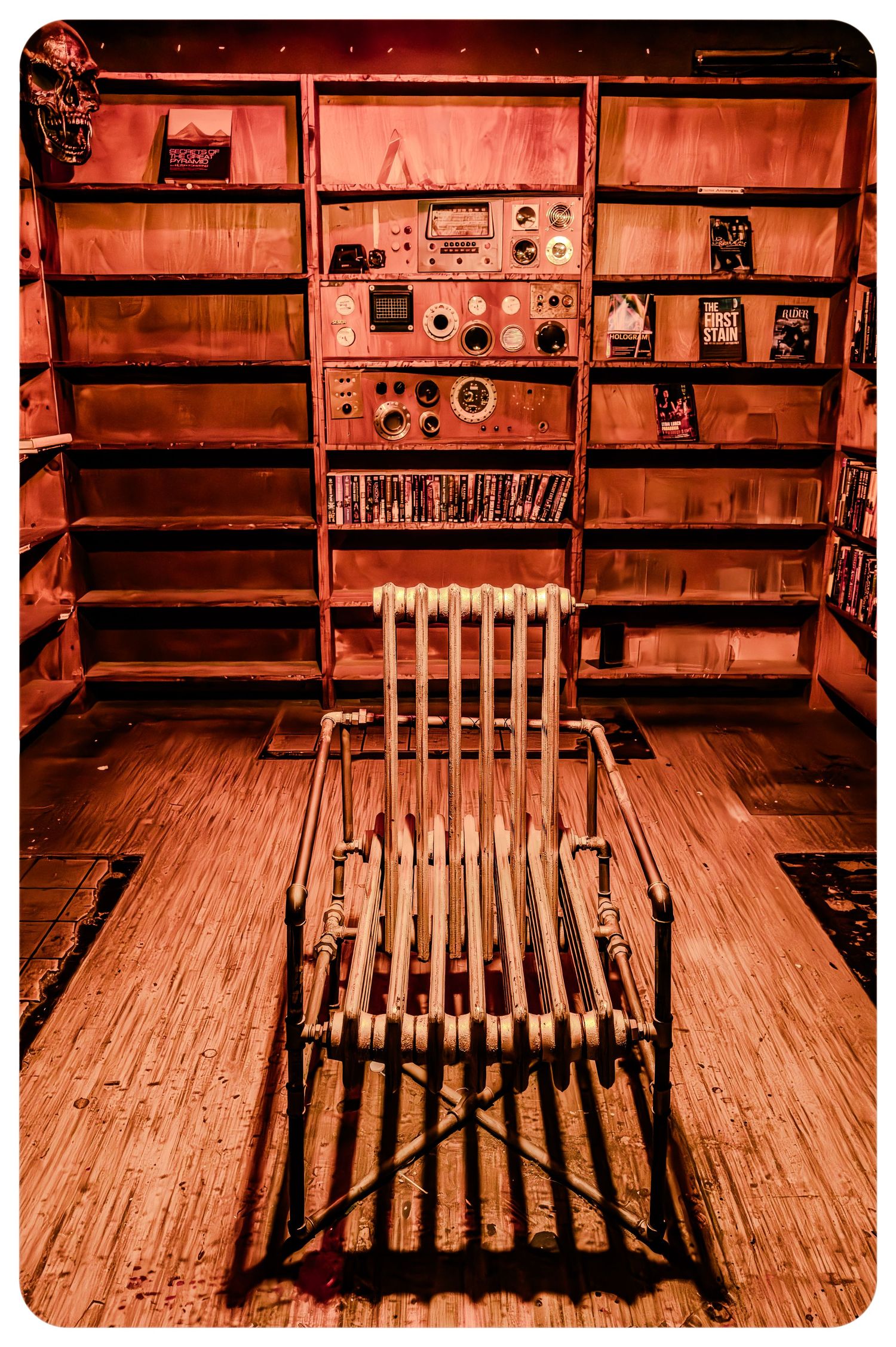 Vintage bamboo chair in red-lit room with shelves and control panel.