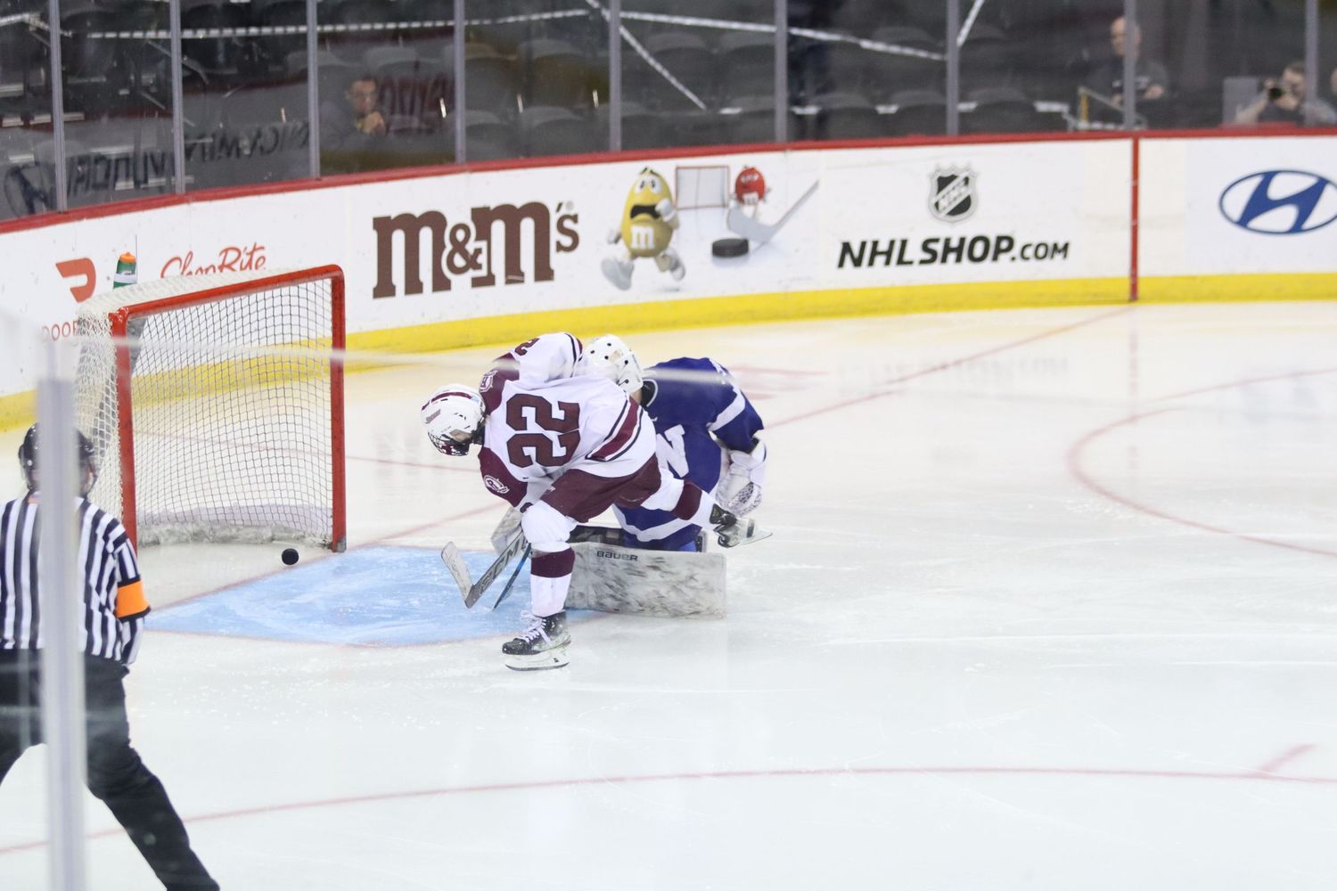 Hockey player scores a goal past the goalie during an ice hockey game.