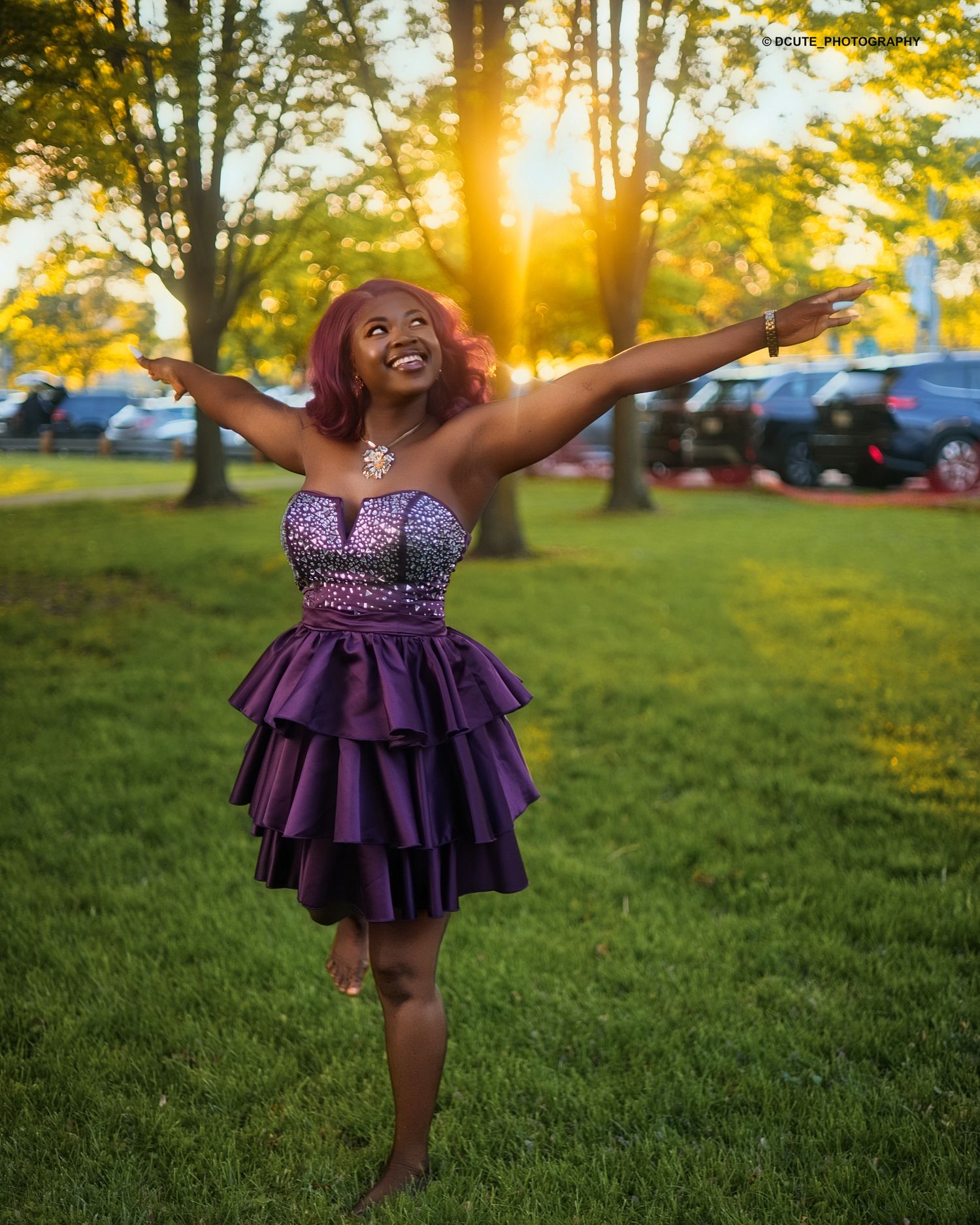 Woman in purple tiered strapless dress with arms outstretched in golden sunset birthday photoshoot toronto