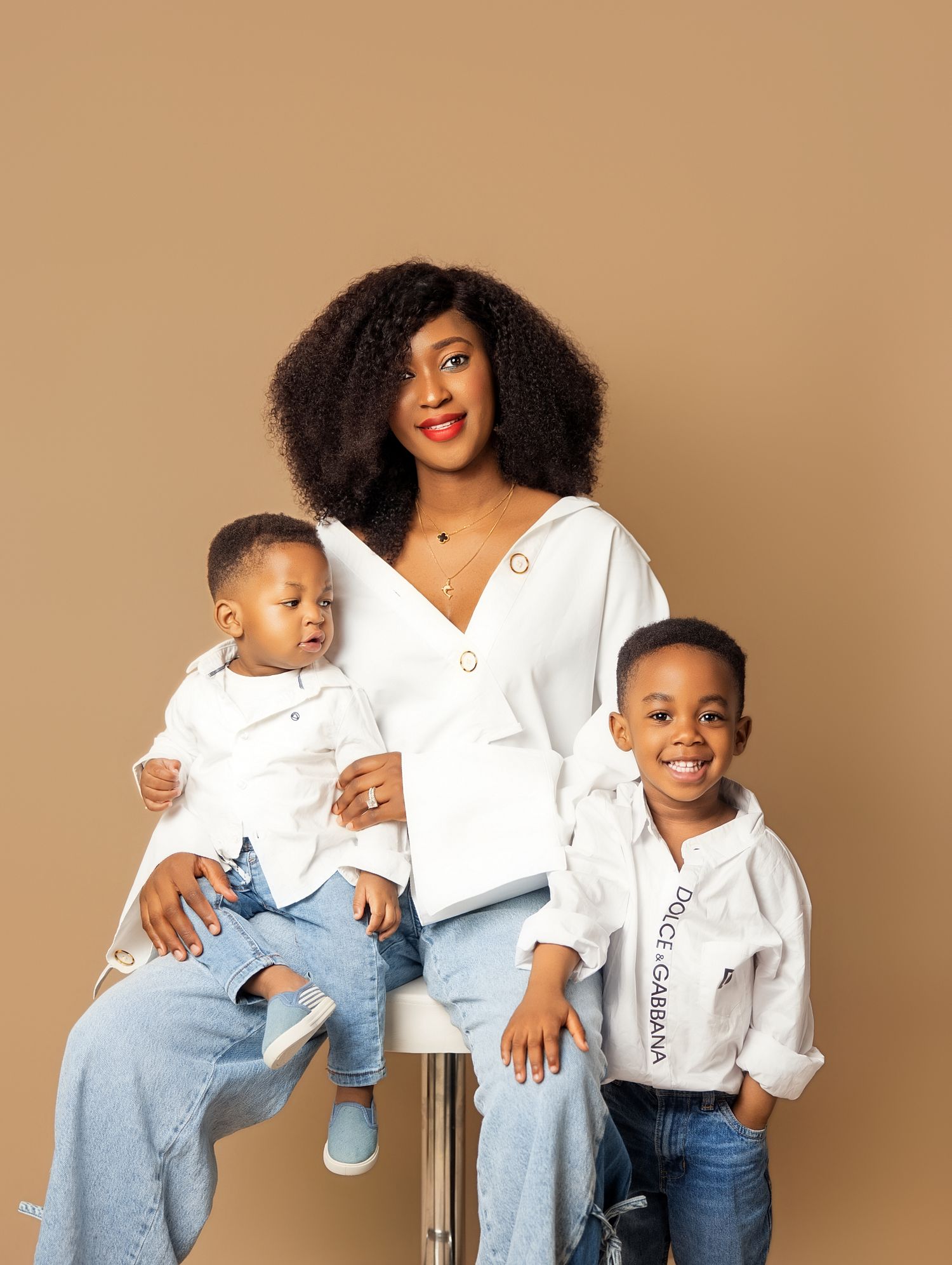 Black mother in white top sitting with two young sons in matching captured by a Family photography near Downtown Toronto