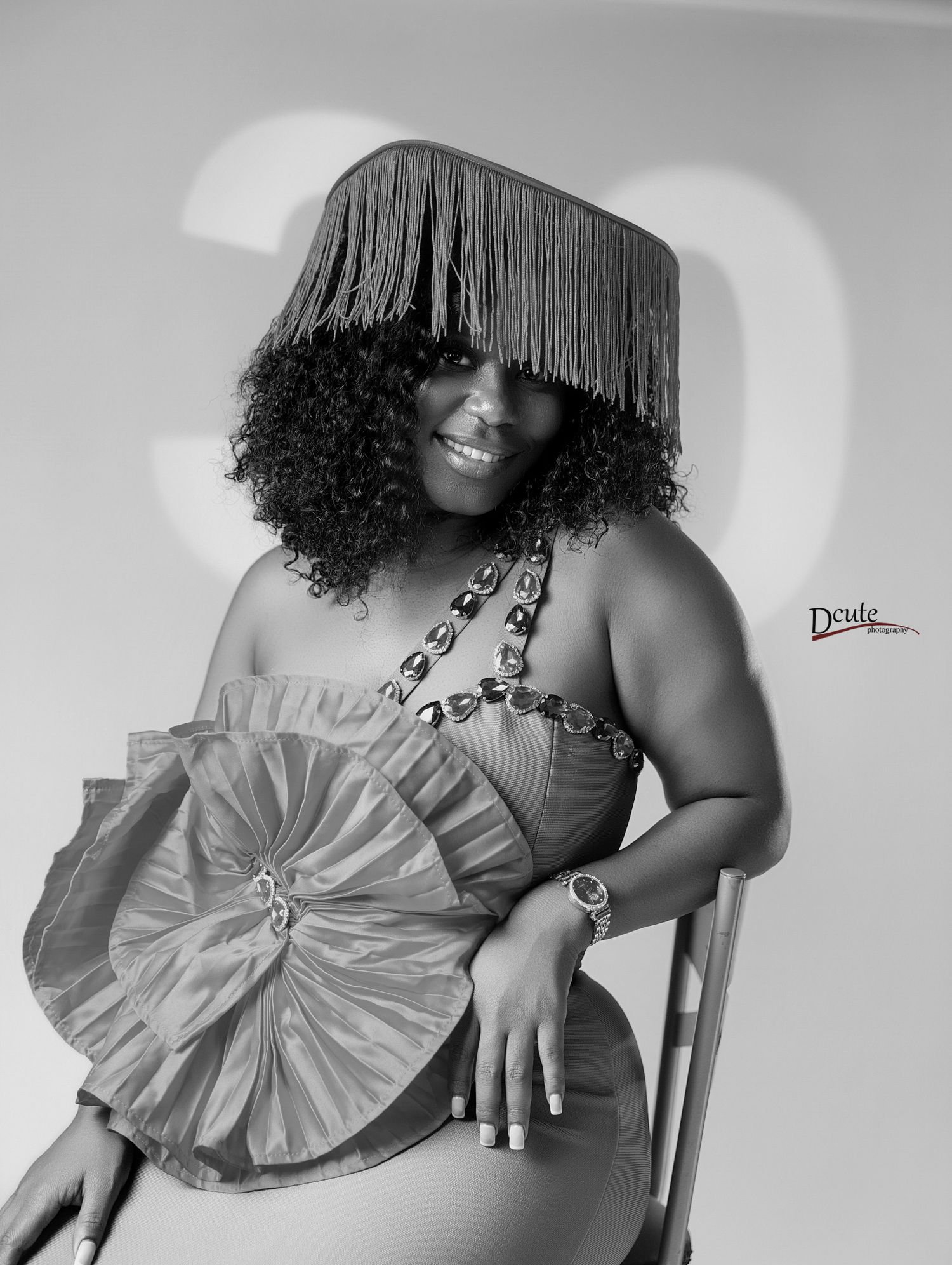 Black and white 30th birthday portrait  in toronto of woman in fringe hat holding decorative fan.