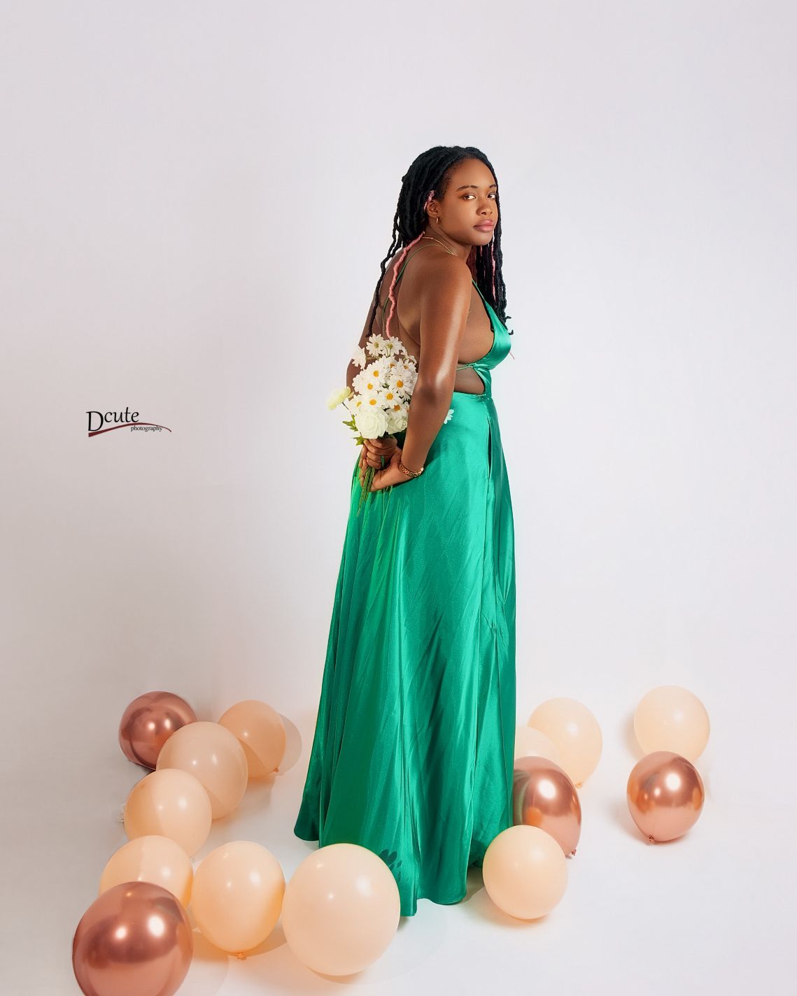 Young woman in backless green satin dress holds bouquet at sweet 16 birthday photo session in toronto