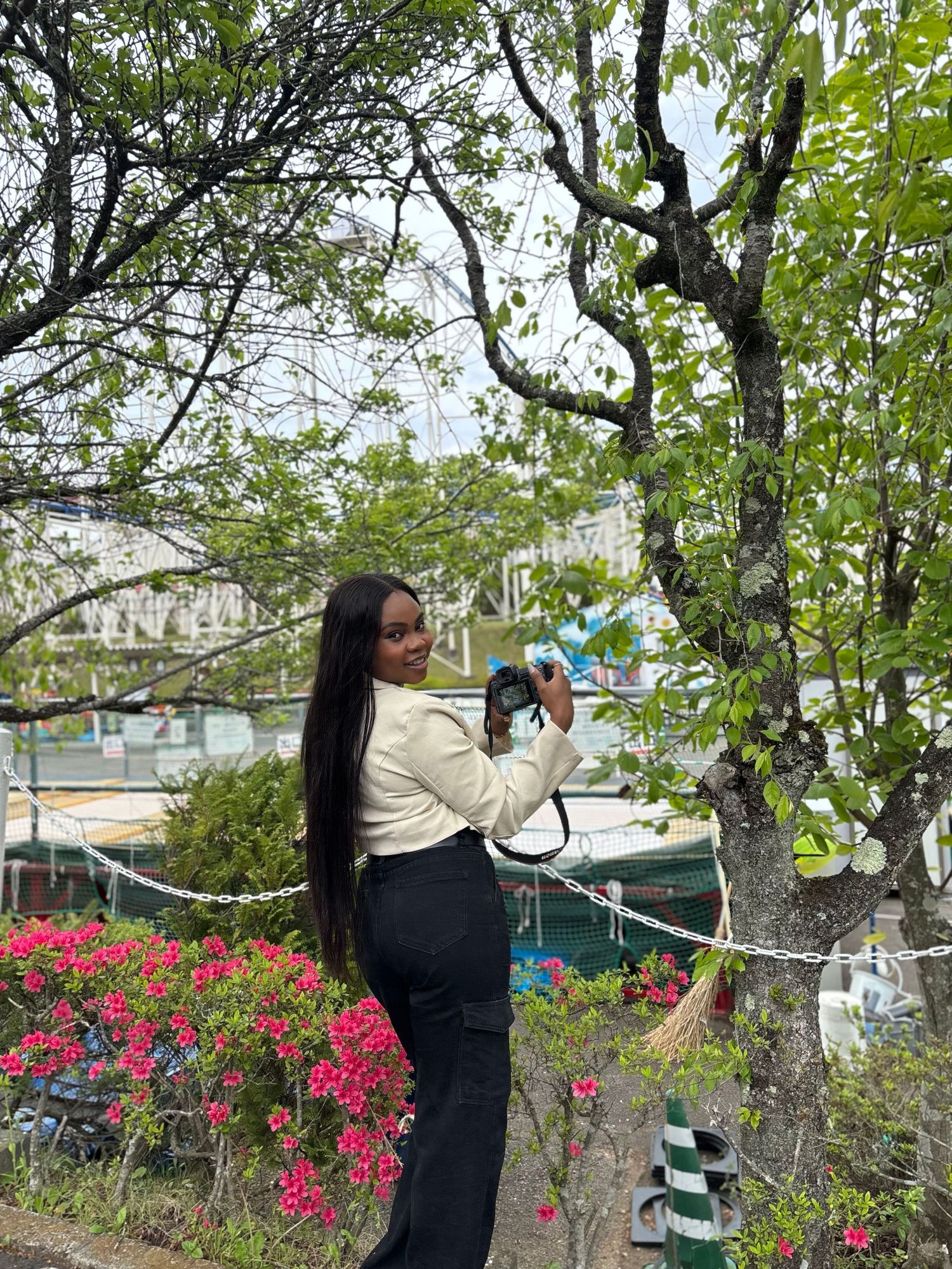 Young Black woman with long straight hair holding camera, she's a Family photographer in Downtown Toronto