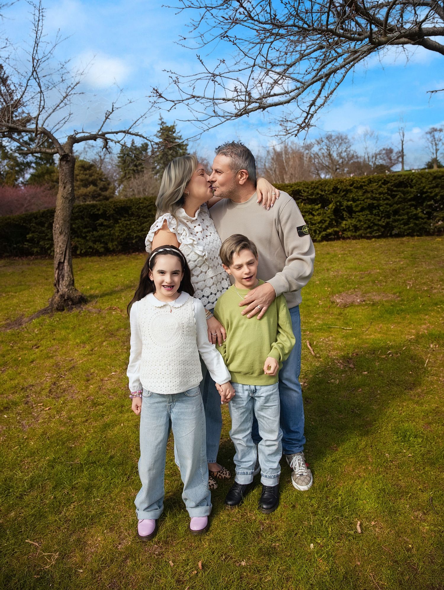 Family photography in Downtown Toronto captures parents sharing a kiss and children standing in front.