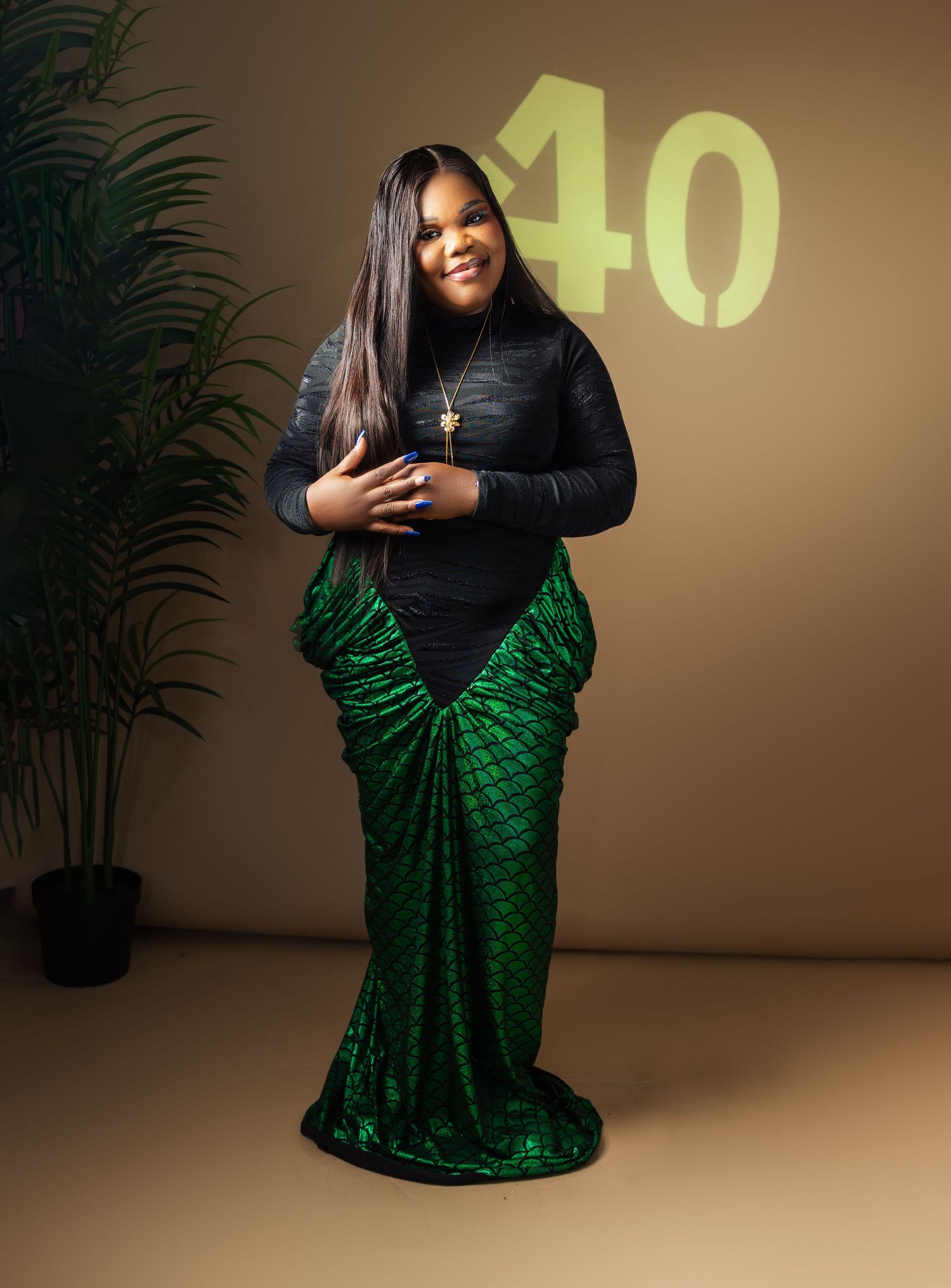 Woman in black top and green mermaid skirt poses at colorful 40th birthday photo shoot in toronto
