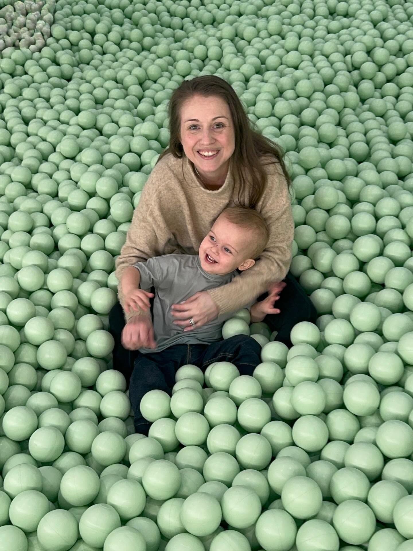 Mother and son surrounded by green balls during a playful family portrait session by Greene House Studios, Chicago suburbs.