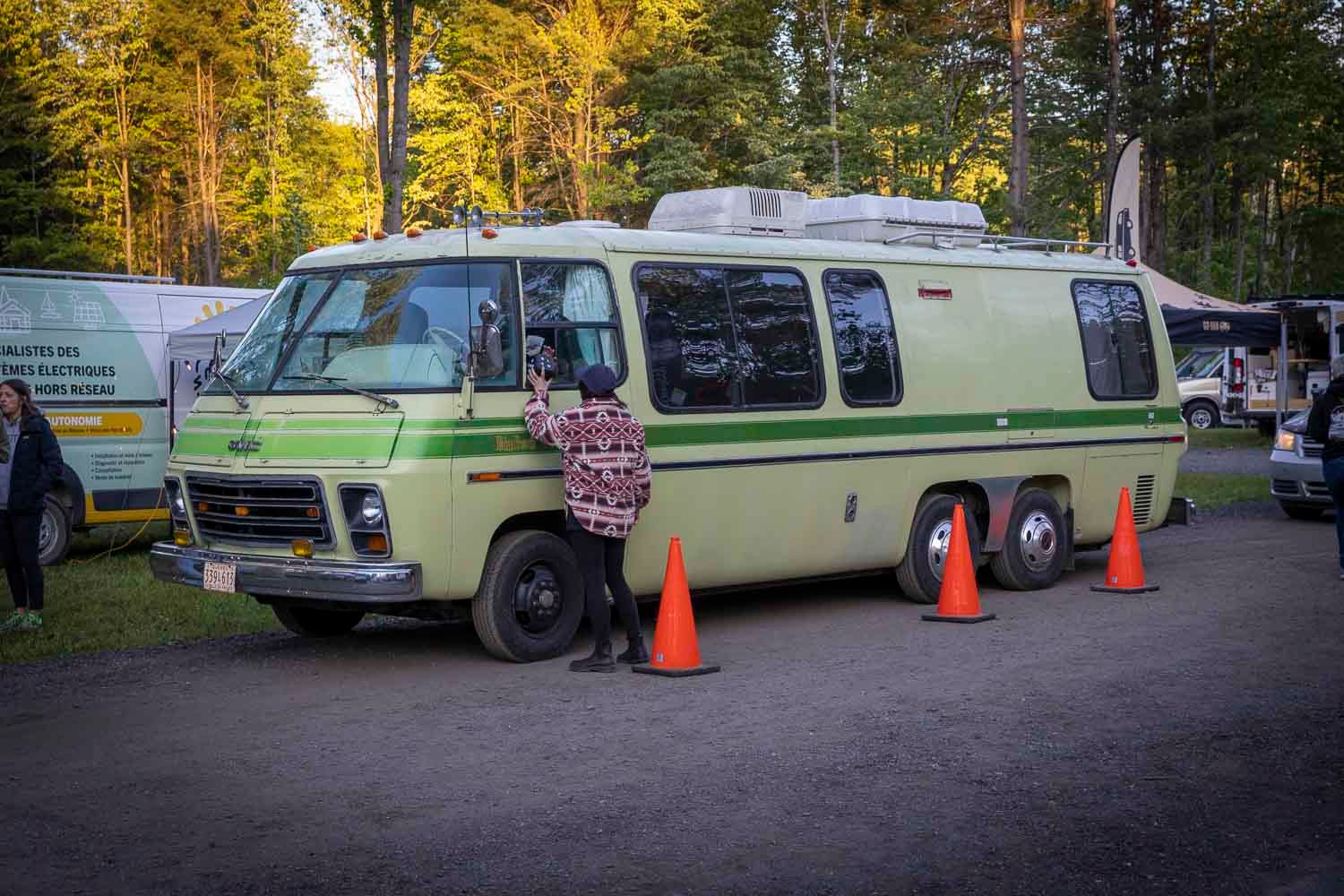 Vintage green Chevrolet RV motorhome parked outdoors with orange traffic cones nearby.