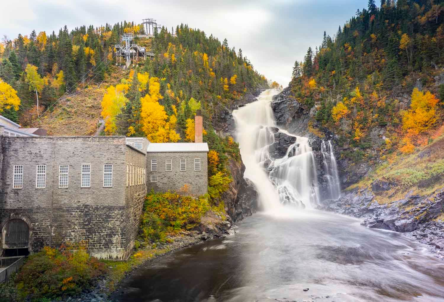 Chutes de Val-Jalbert
Historic stone building beside a dramatic waterfall surrounded by colorful autumn foliage on a rocky hillside.