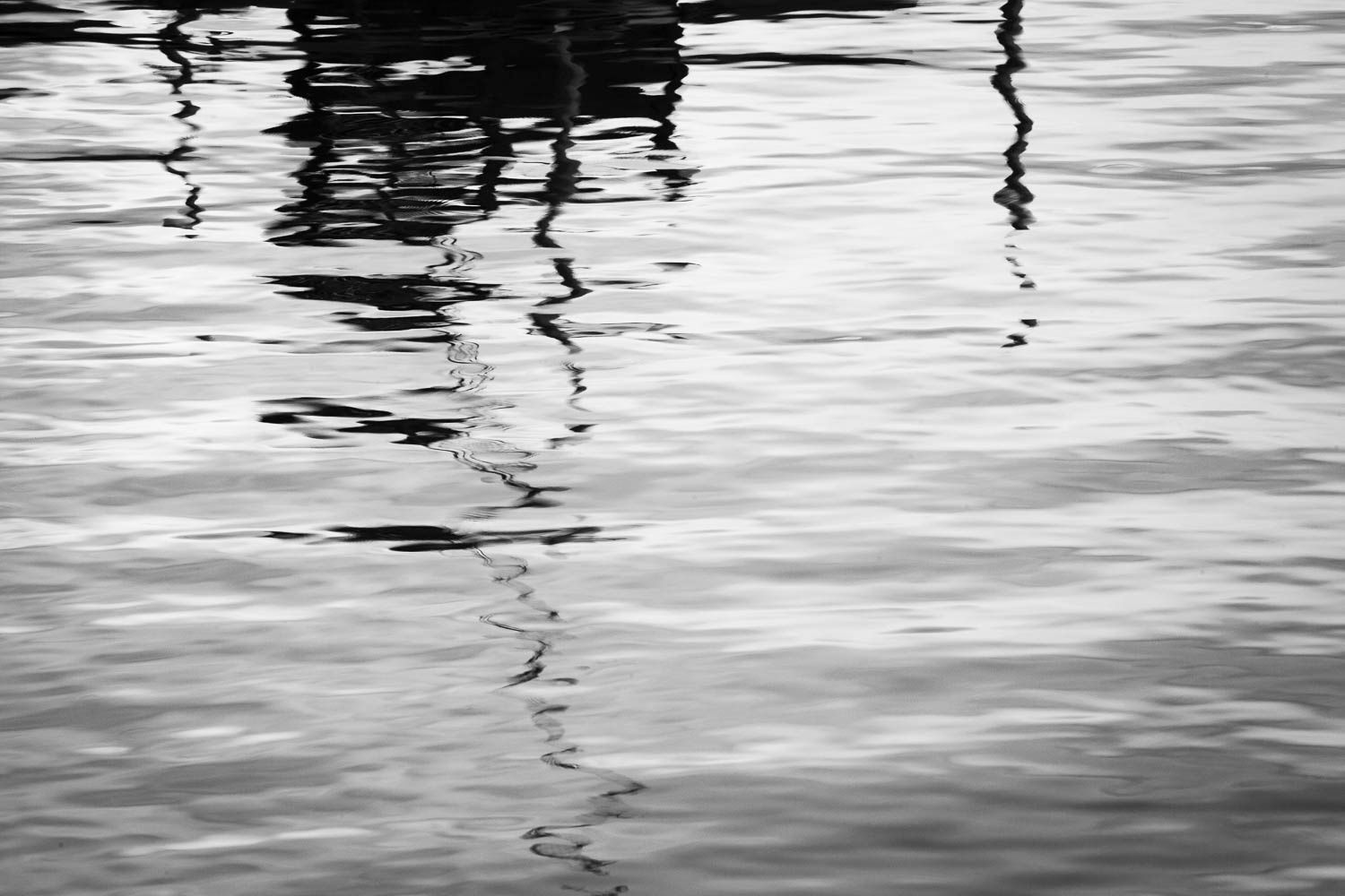 Abstract black and white rippling water surface with soft reflections creating elegant patterns.