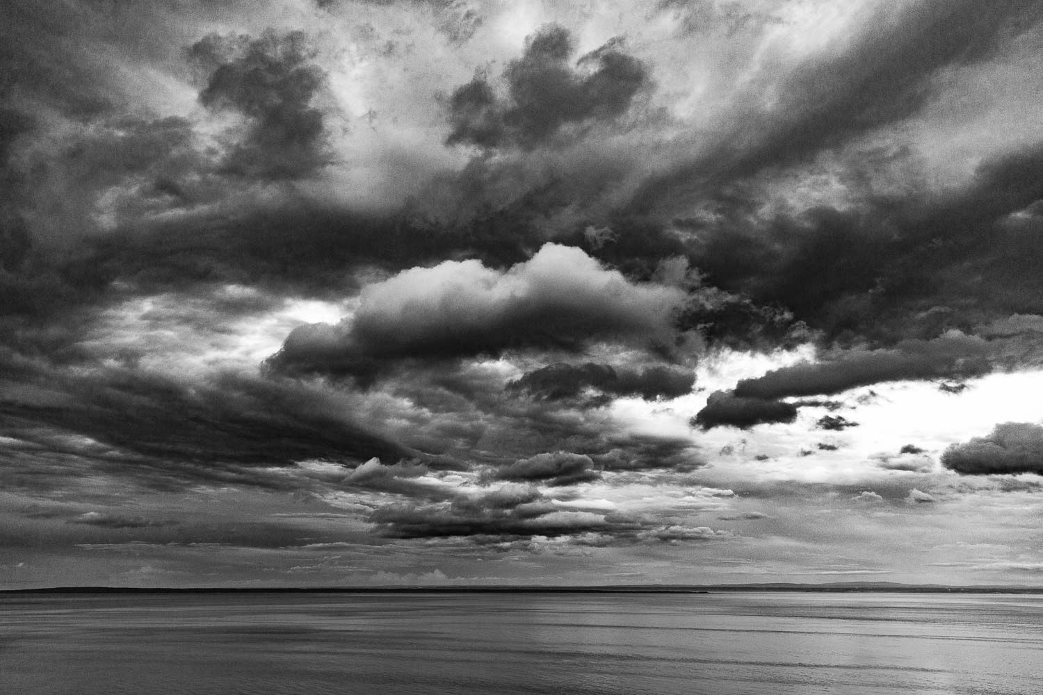 Ciel nuageux et fleuve saint-Laurent
Québec, Canada
Dramatic black and white seascape with stormy clouds over calm ocean waters.