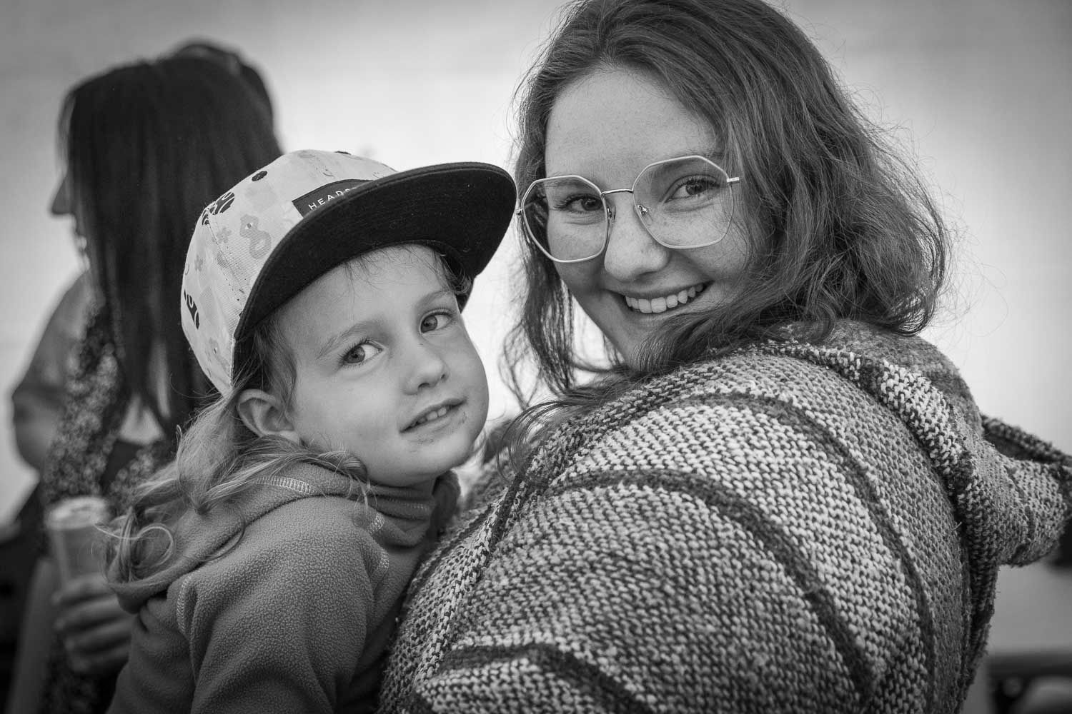 Black and white photo of a smiling woman and young child posing together.