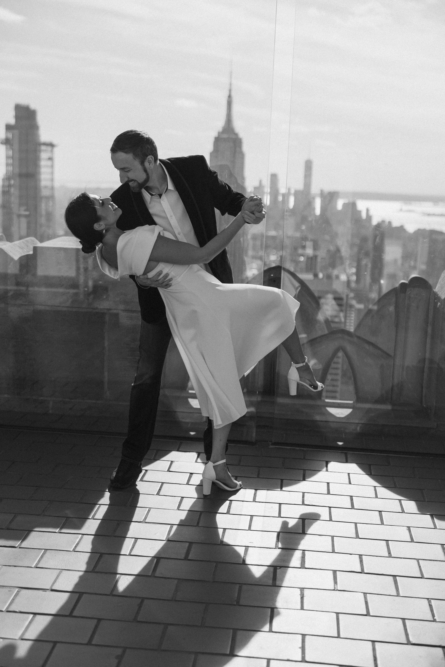 Dramatic black and white dance dip with New York City skyline backdrop.