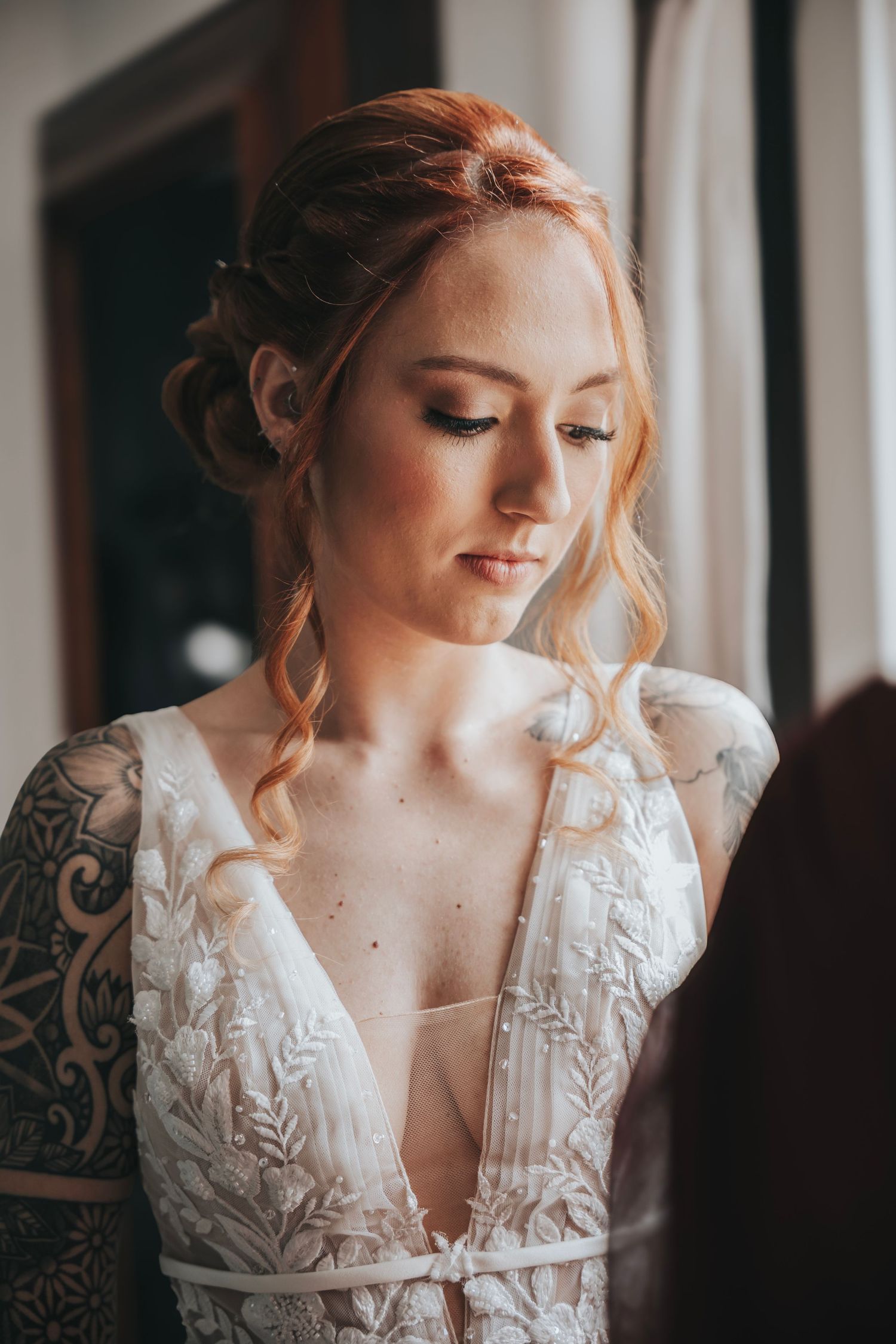 Soft bridal portrait by window showcasing delicate lace wedding dress details.