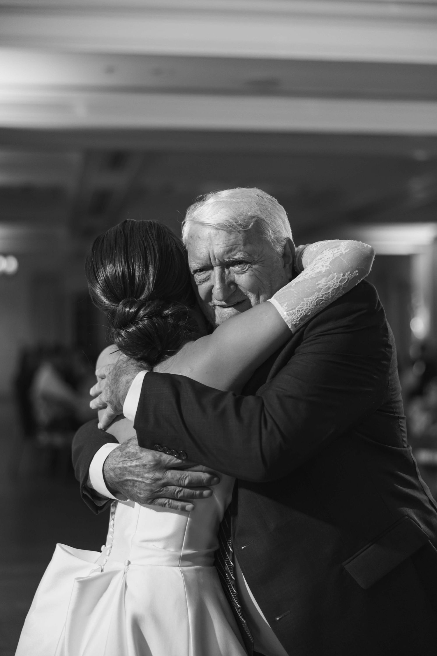 An emotional black and white moment during a wedding reception dance.