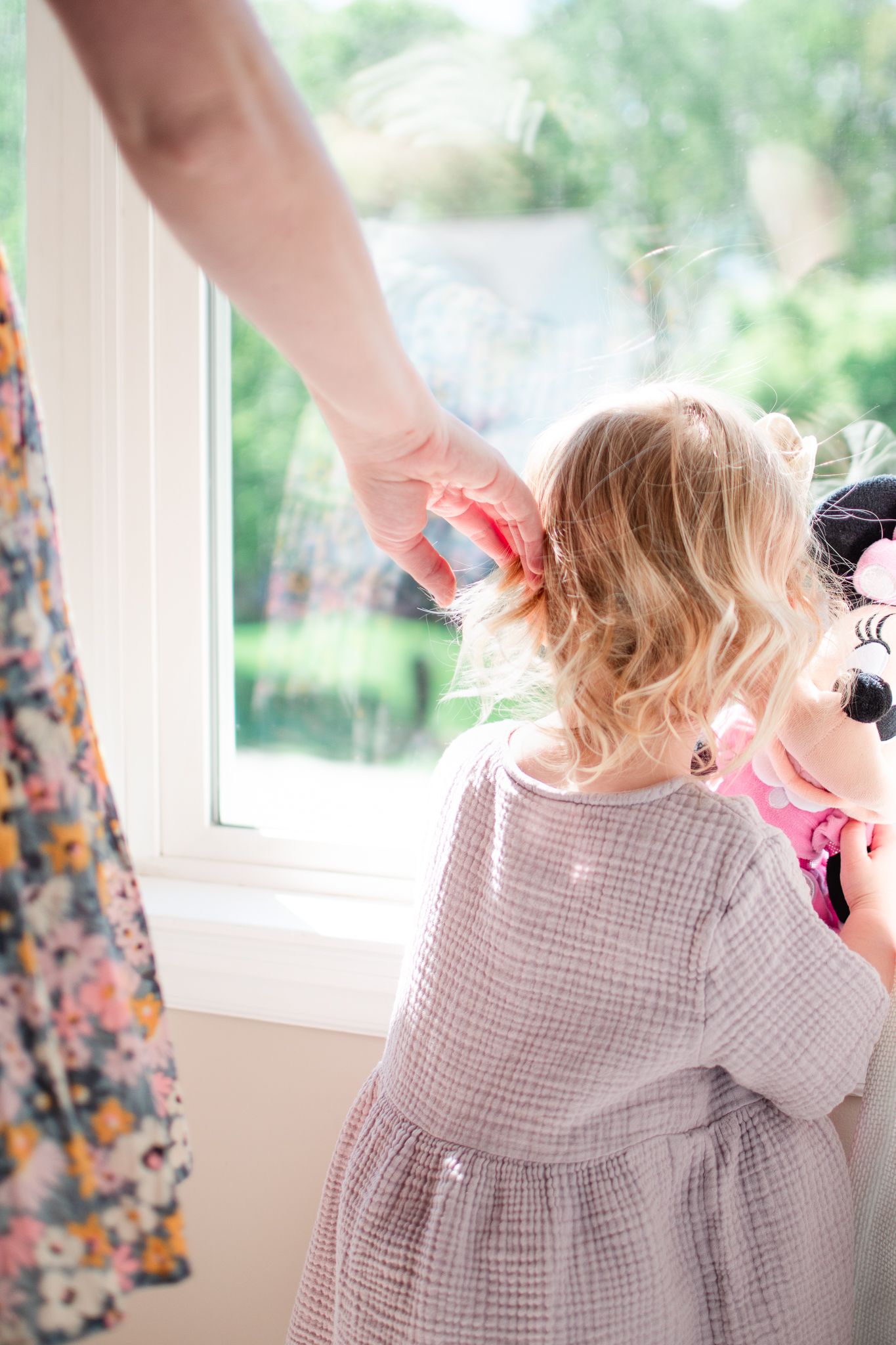 Mom brushes her daughter's hair away.