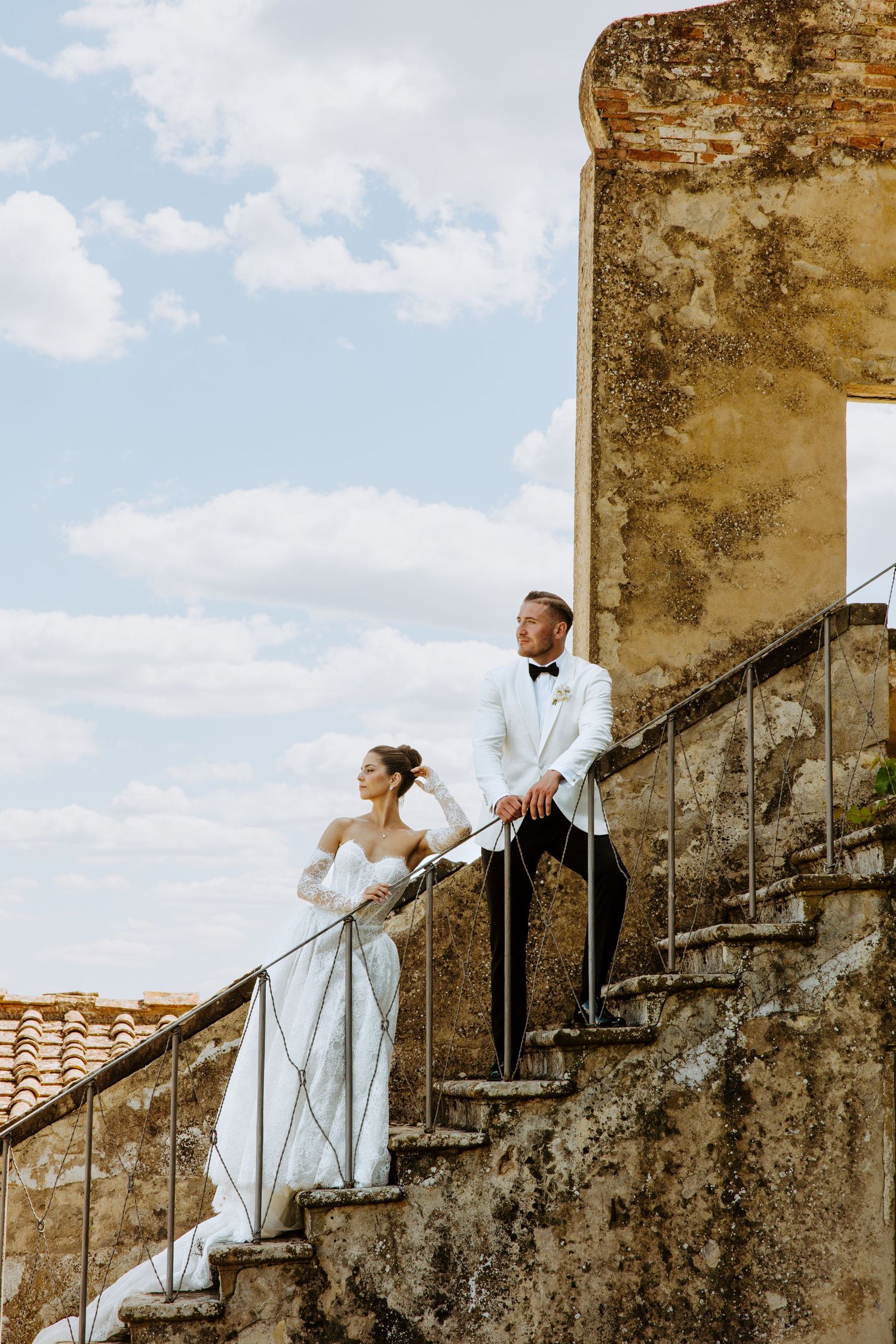A couple in wedding attire poses on an ancient stone staircase in a romantic sequence of ascending photos.