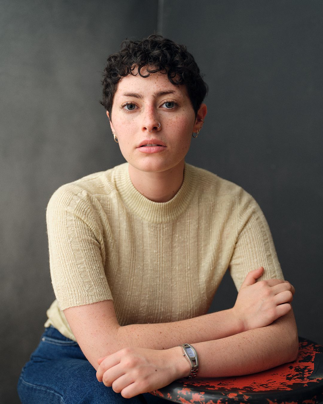Moody headshot of a woman with short hair against a dark backdrop.