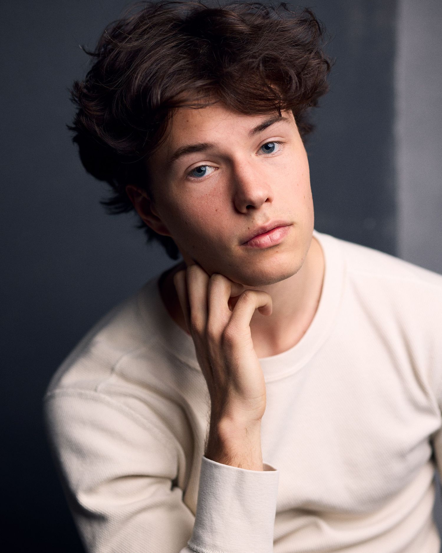 Young actor headshot on dark blue background.
