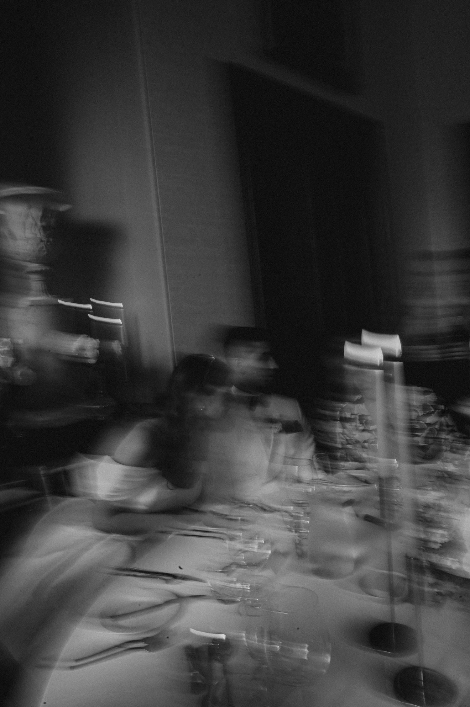 Artistic blurred black and white photo of wedding reception dining setup.