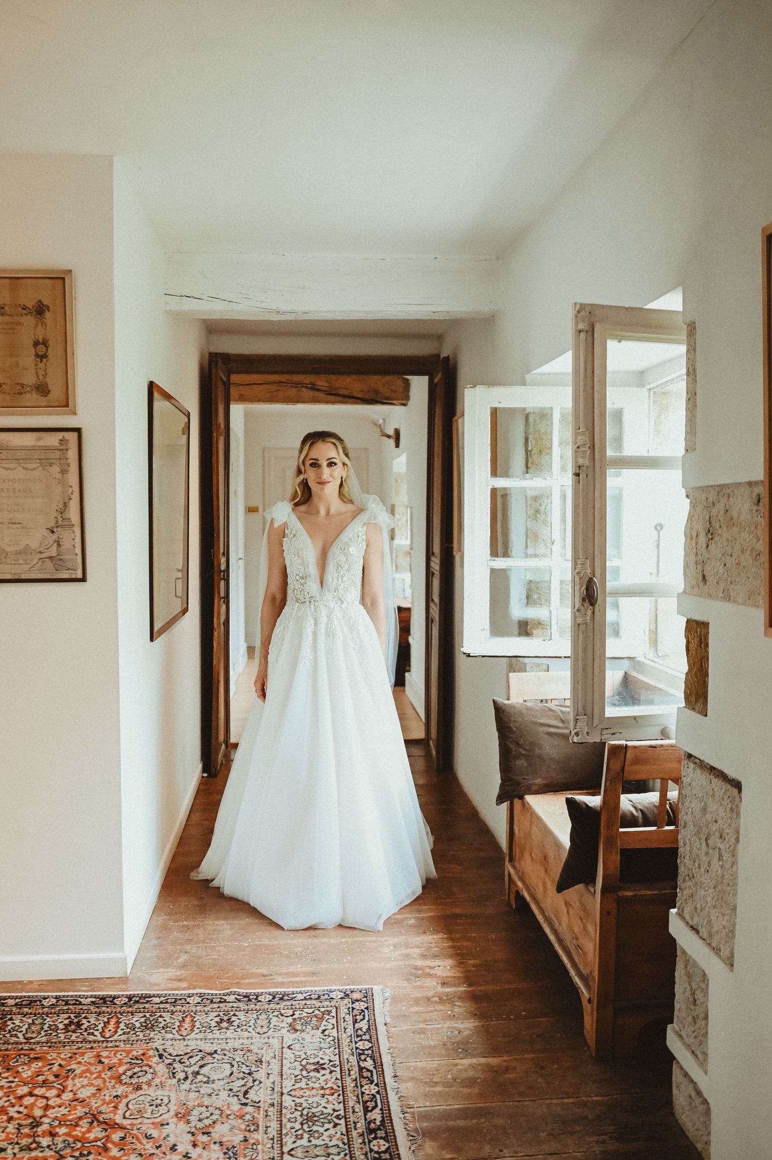 Wedding gown photograph in a rustic hallway with hardwood floors and vintage furniture.