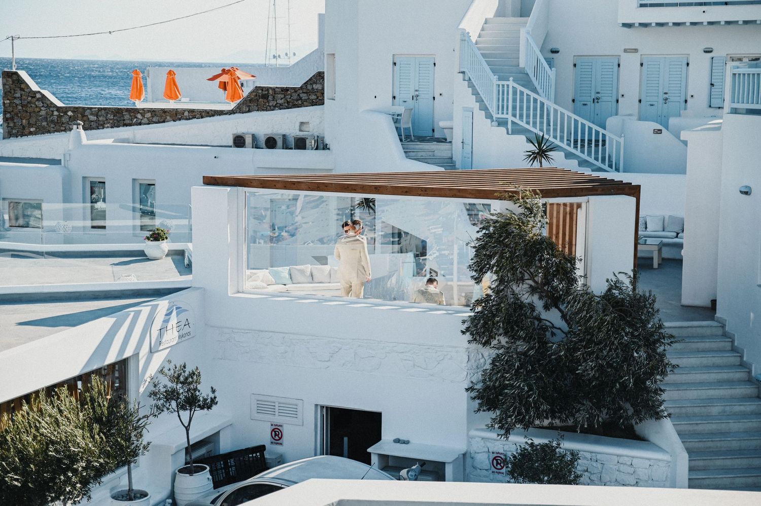 White Mediterranean villa with blue accents and multiple levels overlooking the sea.