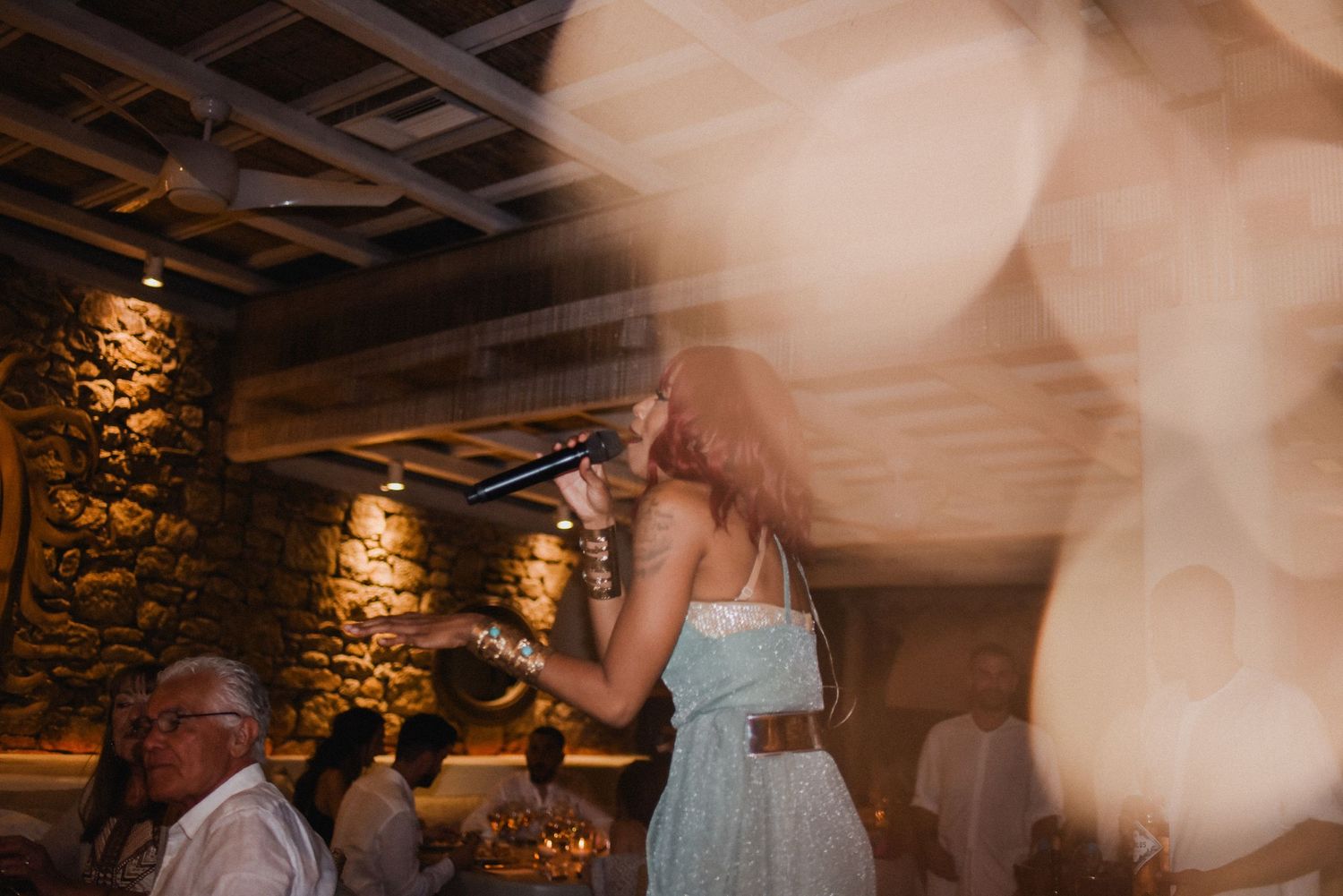 A wedding celebration captured in motion blur with warm ambient lighting and stone walls.