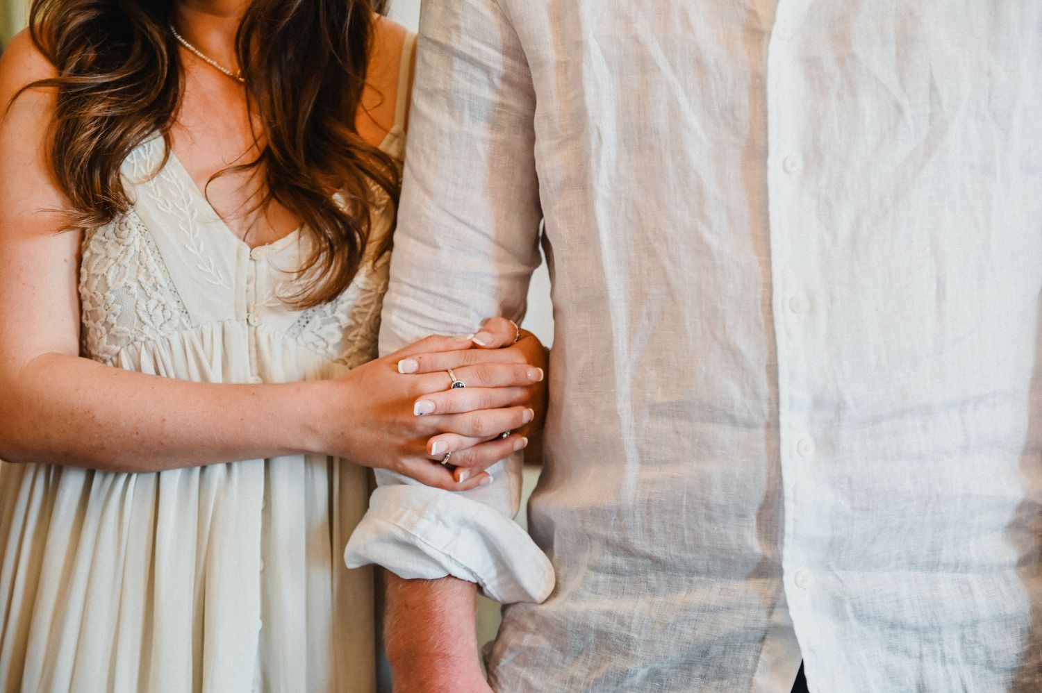 A close-up shot of hands clasped together showing emotional connection.