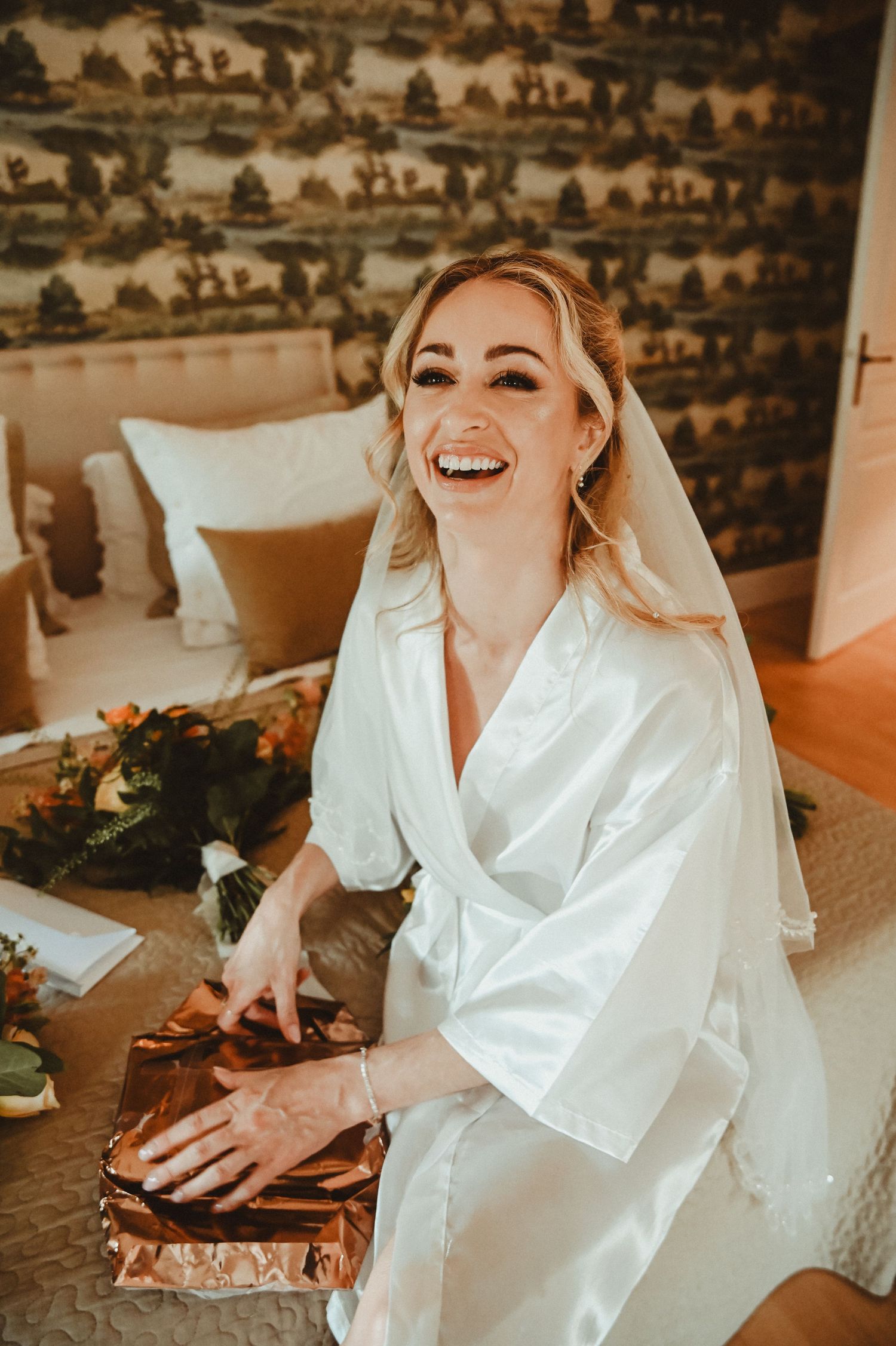 Joyful wedding preparation moment with copper decor and floral arrangements.