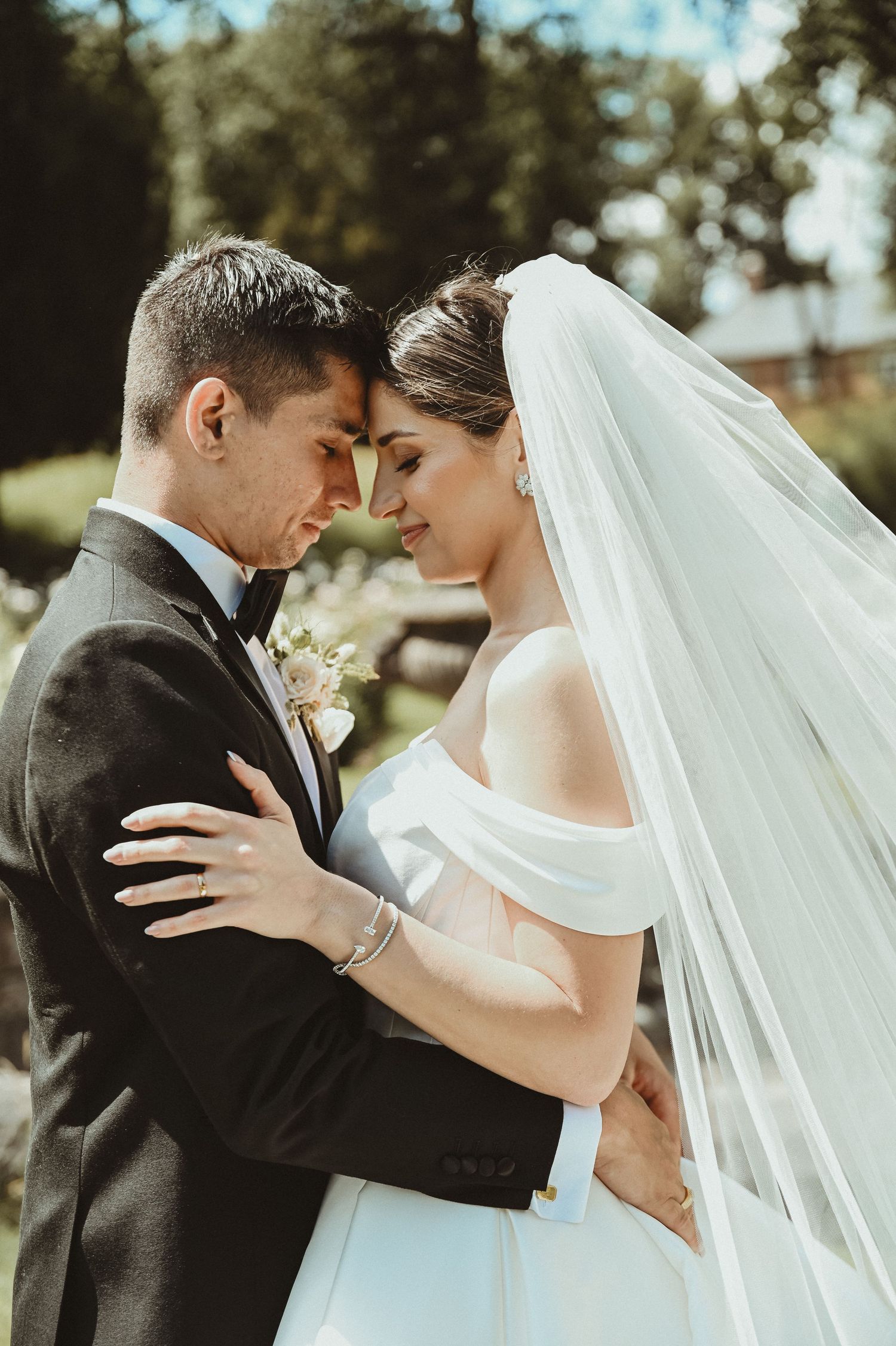 An intimate wedding moment captured in a garden setting with soft natural lighting.