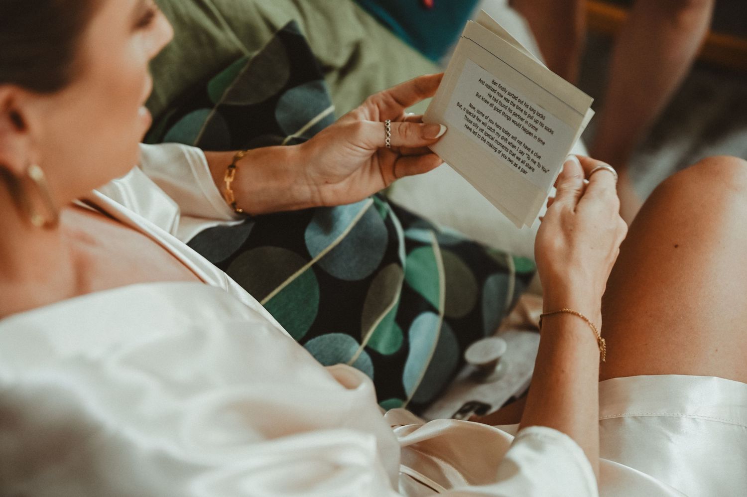 Someone reading a document while wearing a white floral dress.