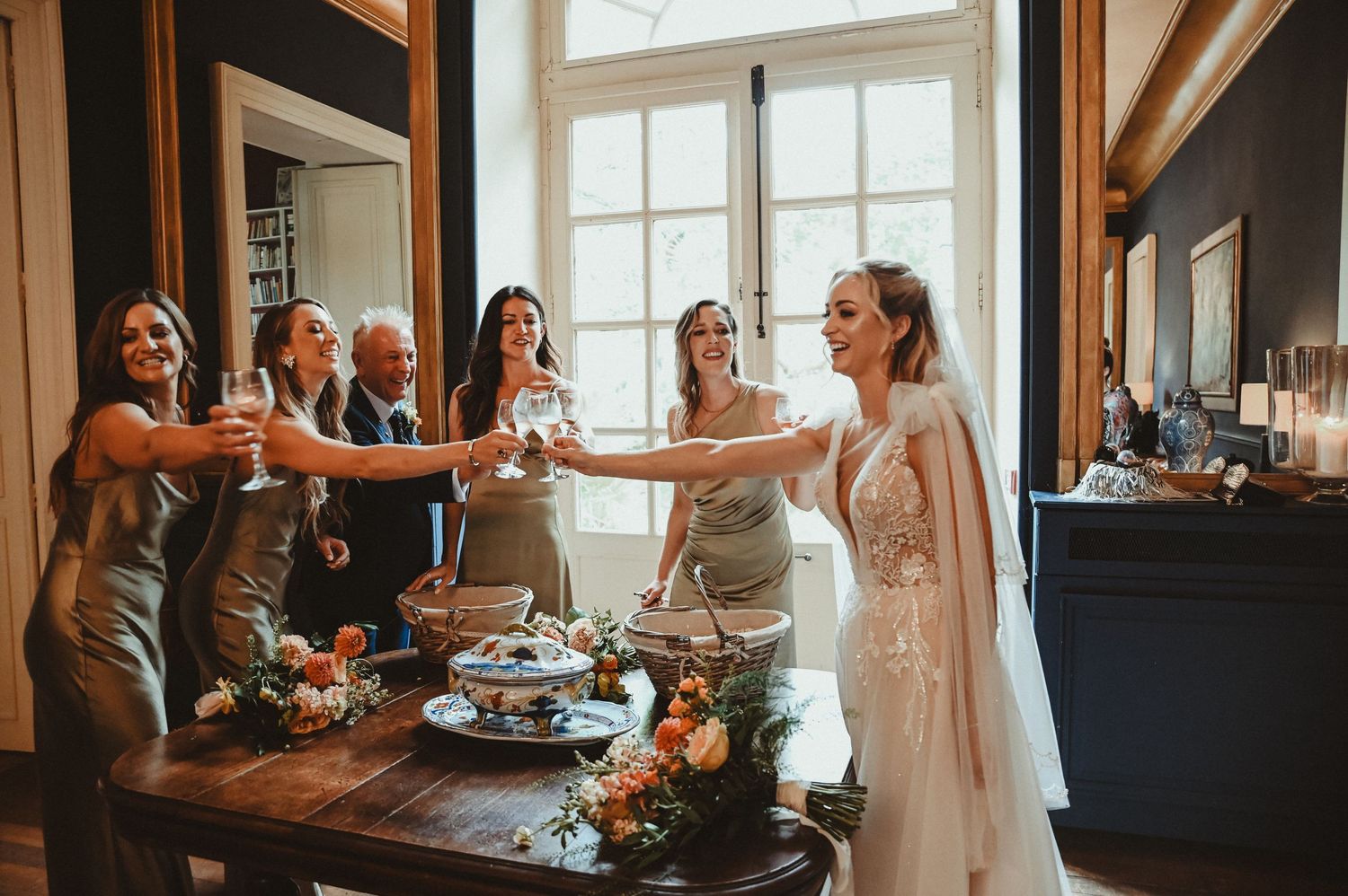Wedding celebration with drinks and snacks in a sunlit room with vintage decor.