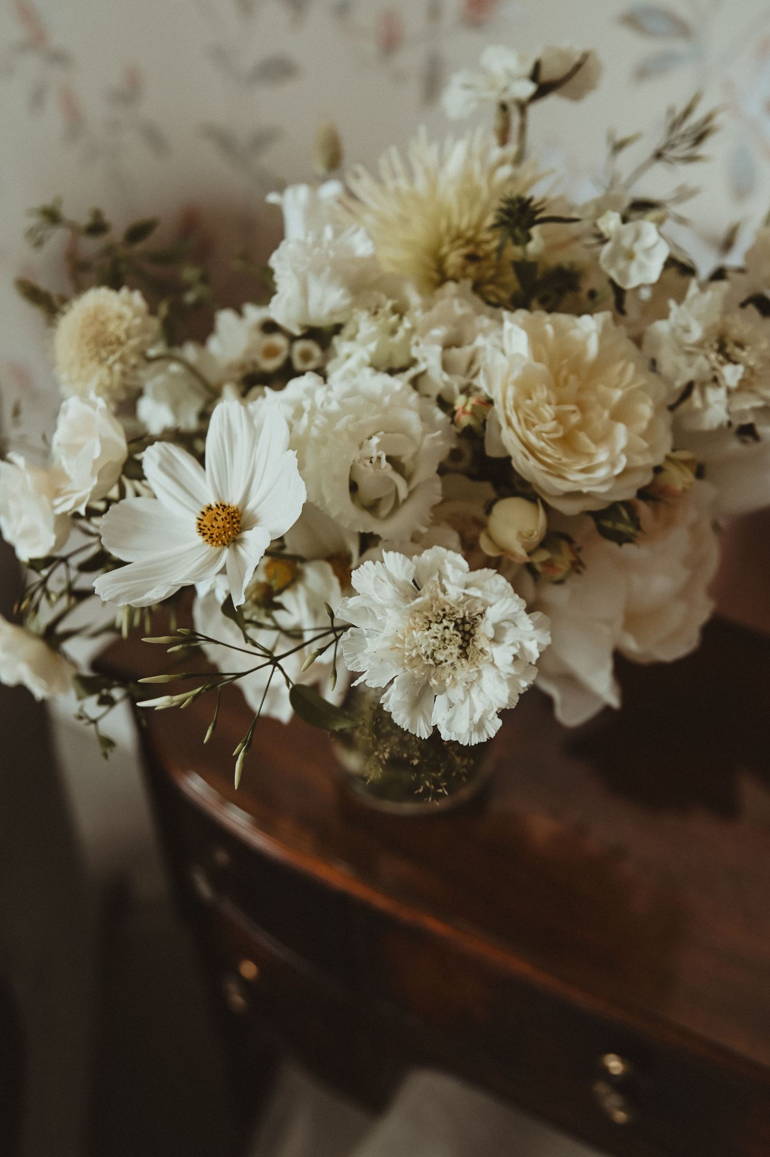 A delicate arrangement of white and cream flowers in vintage-inspired wedding bouquet.