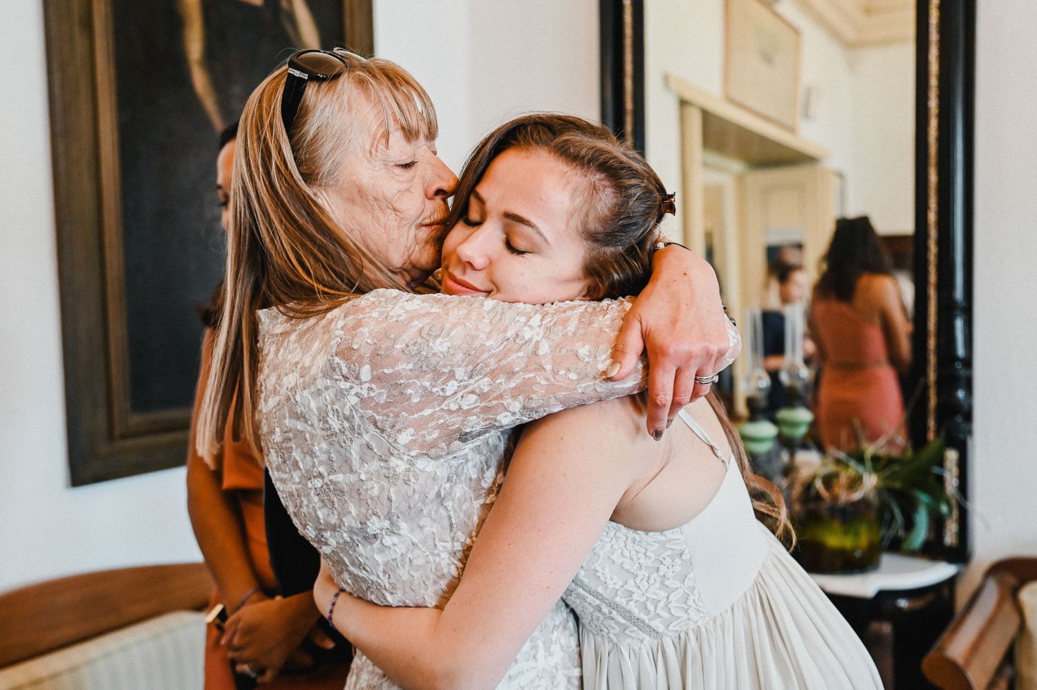 Two people share an emotional embrace in an indoor setting.
