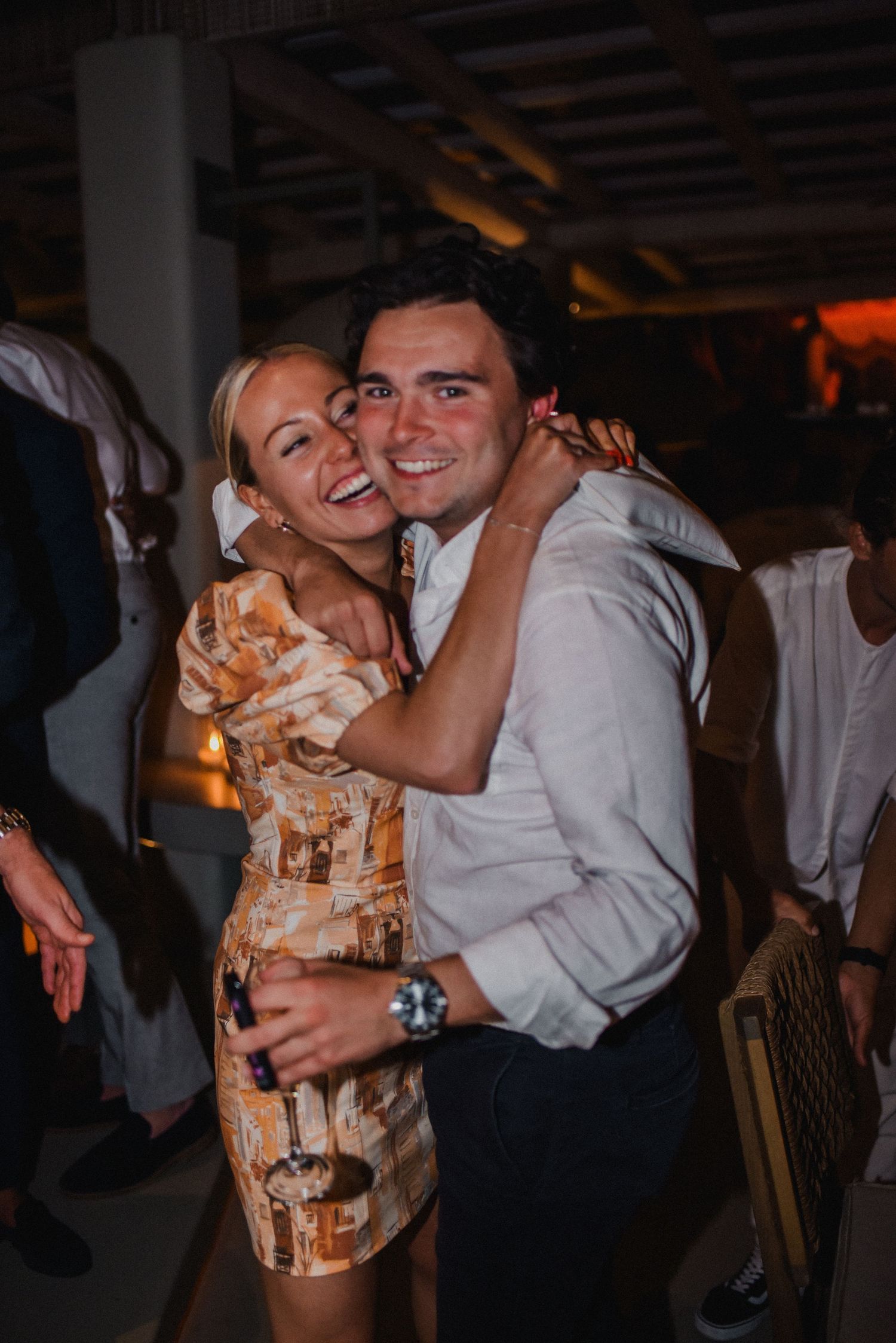 Couple embraces while dancing at an evening celebration in an industrial-style venue.