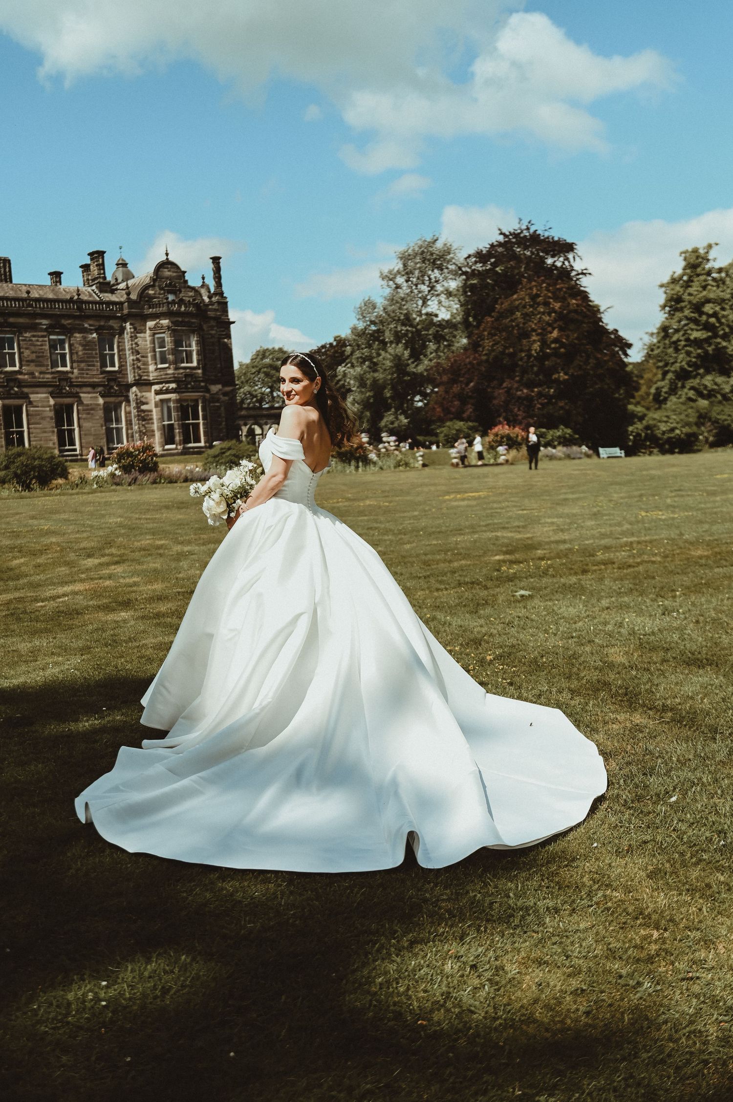Stunning white ballgown with cathedral train photographed against historic stone manor house.