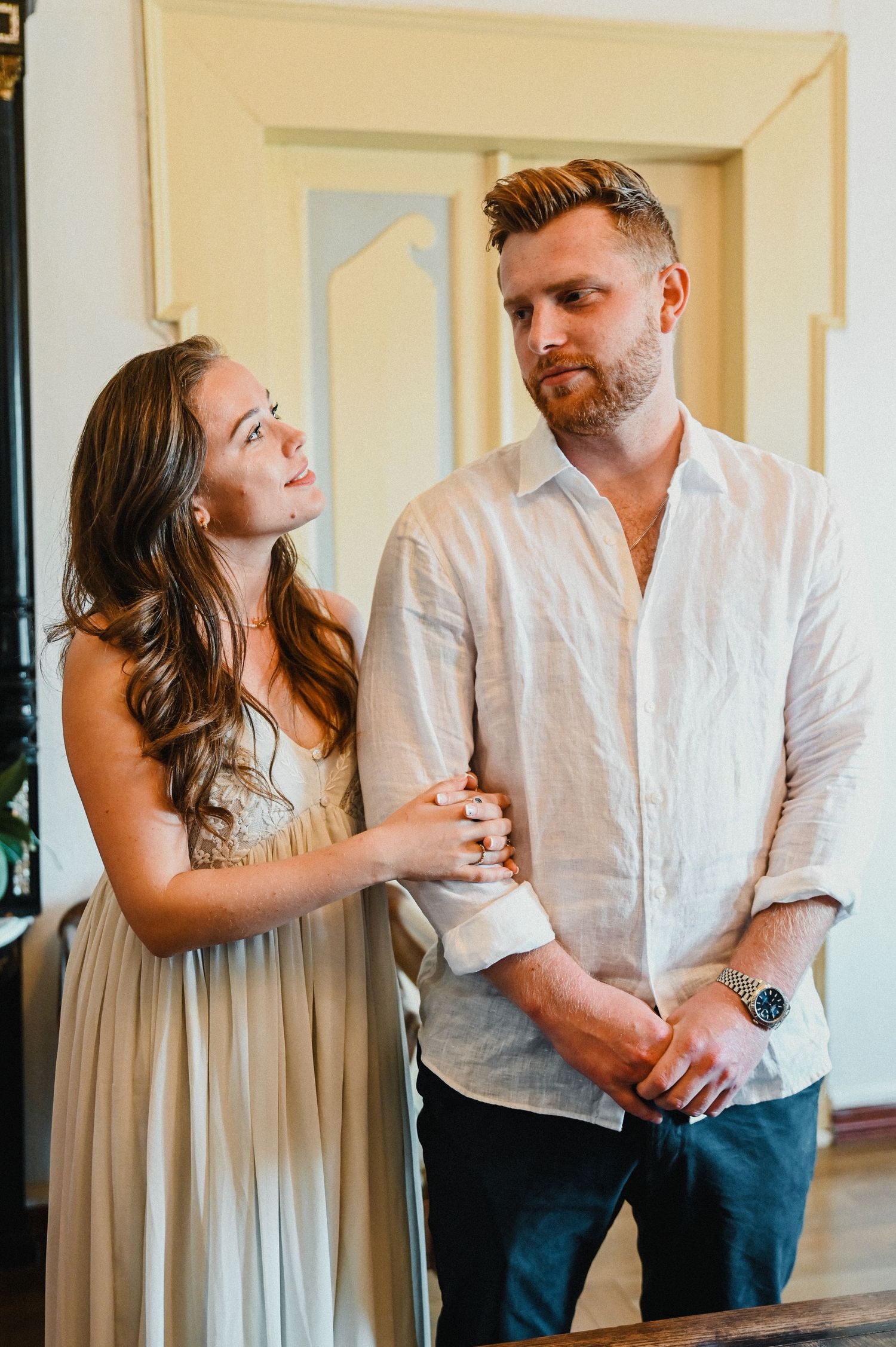 A casual indoor portrait showing a couple sharing a tender moment.