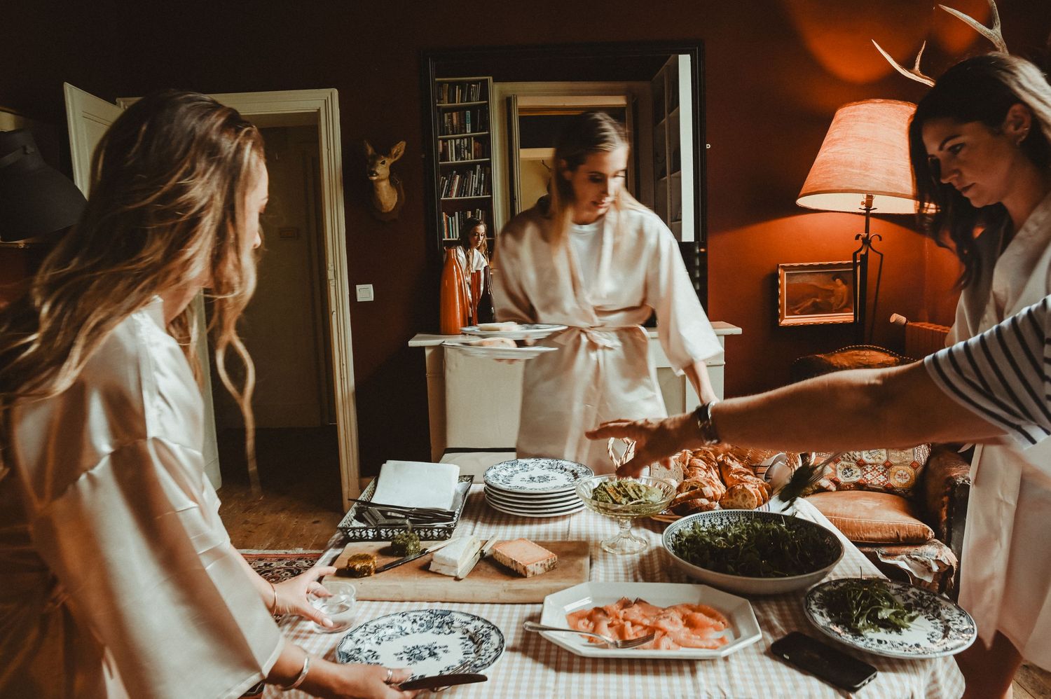 Casual gathering around a dining table with various dishes and snacks.