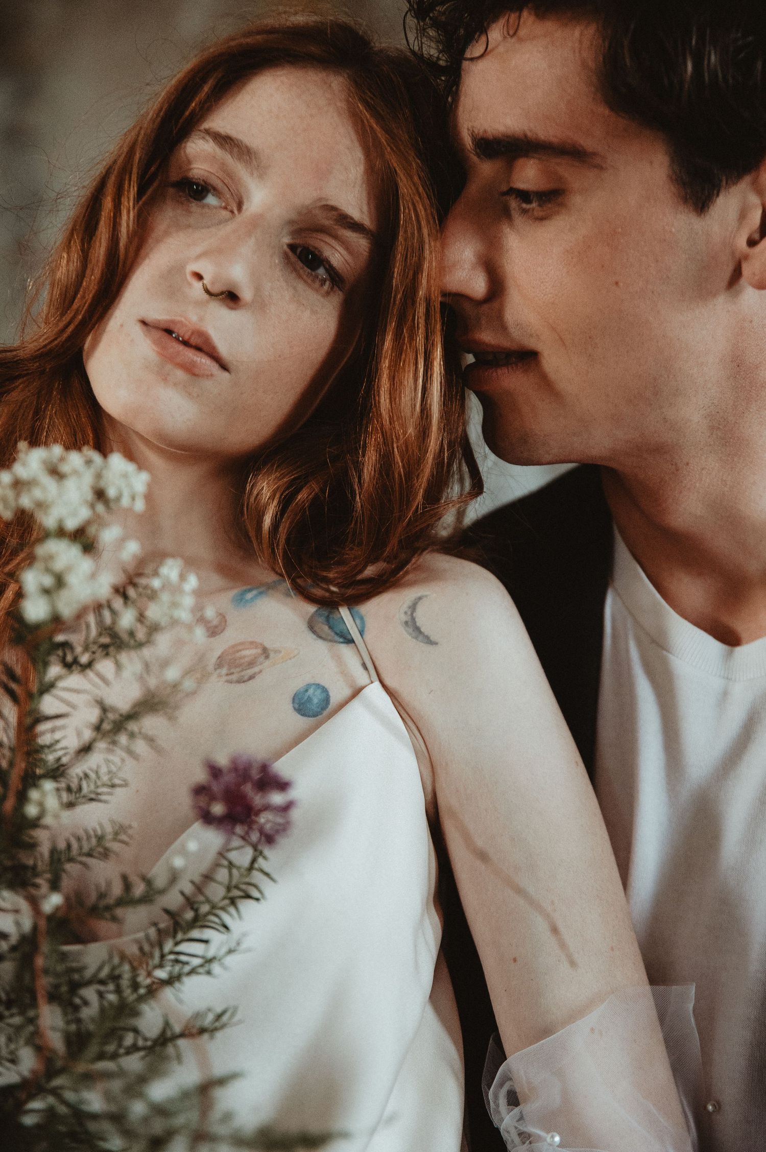 Intimate portrait of a couple with a wildflower bouquet in warm vintage tones.