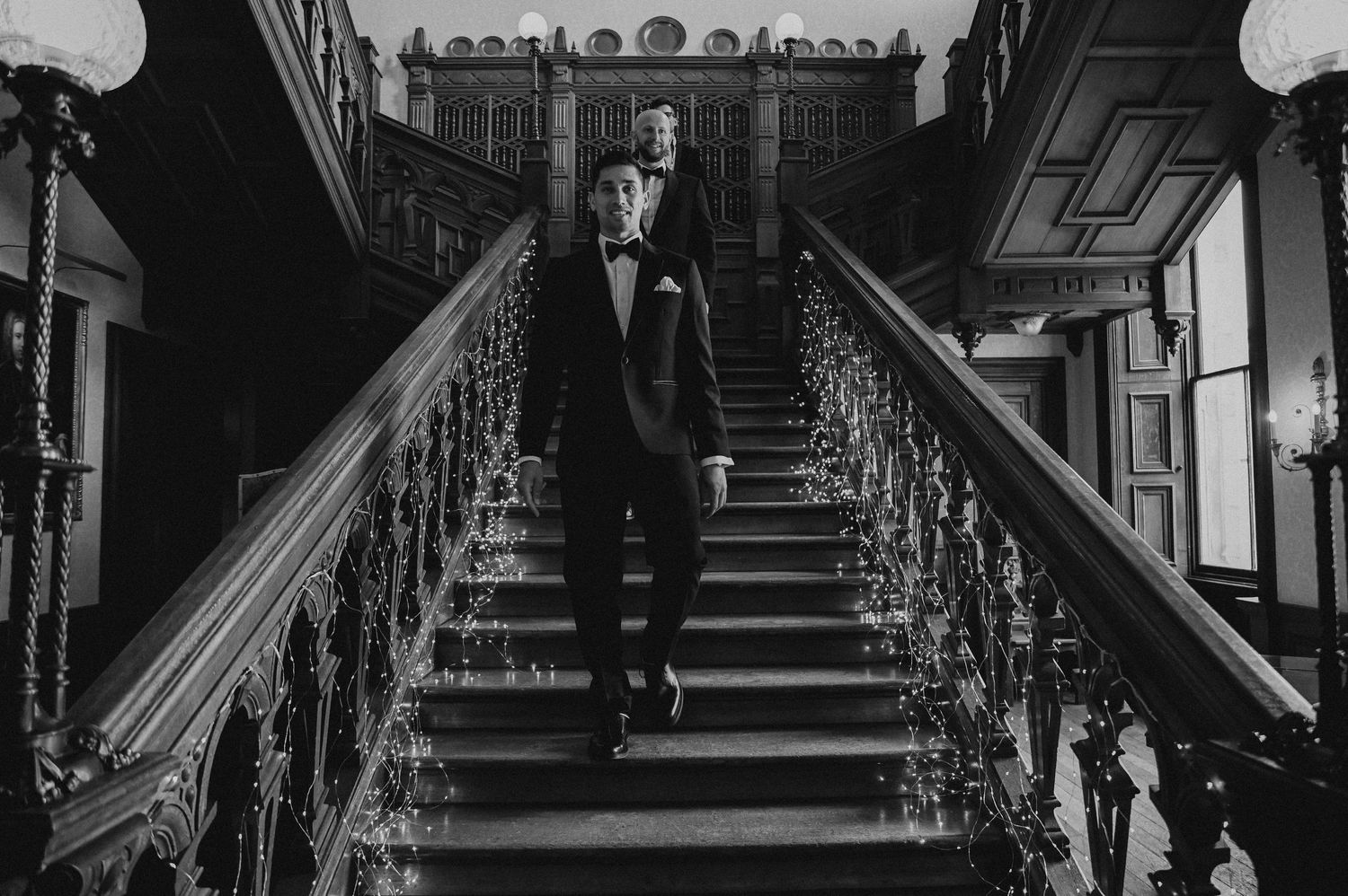 A silhouette descending an elegant vintage staircase with ornate iron railings.
