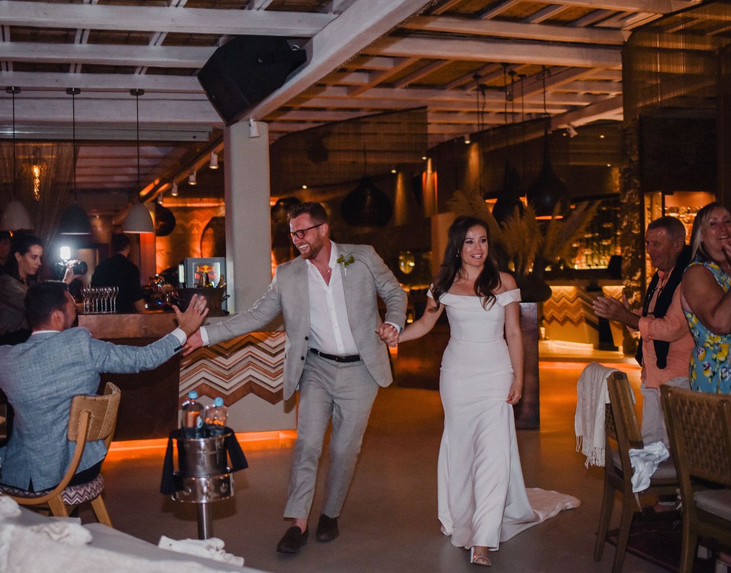 Wedding reception dance party in dimly lit industrial-style venue.
