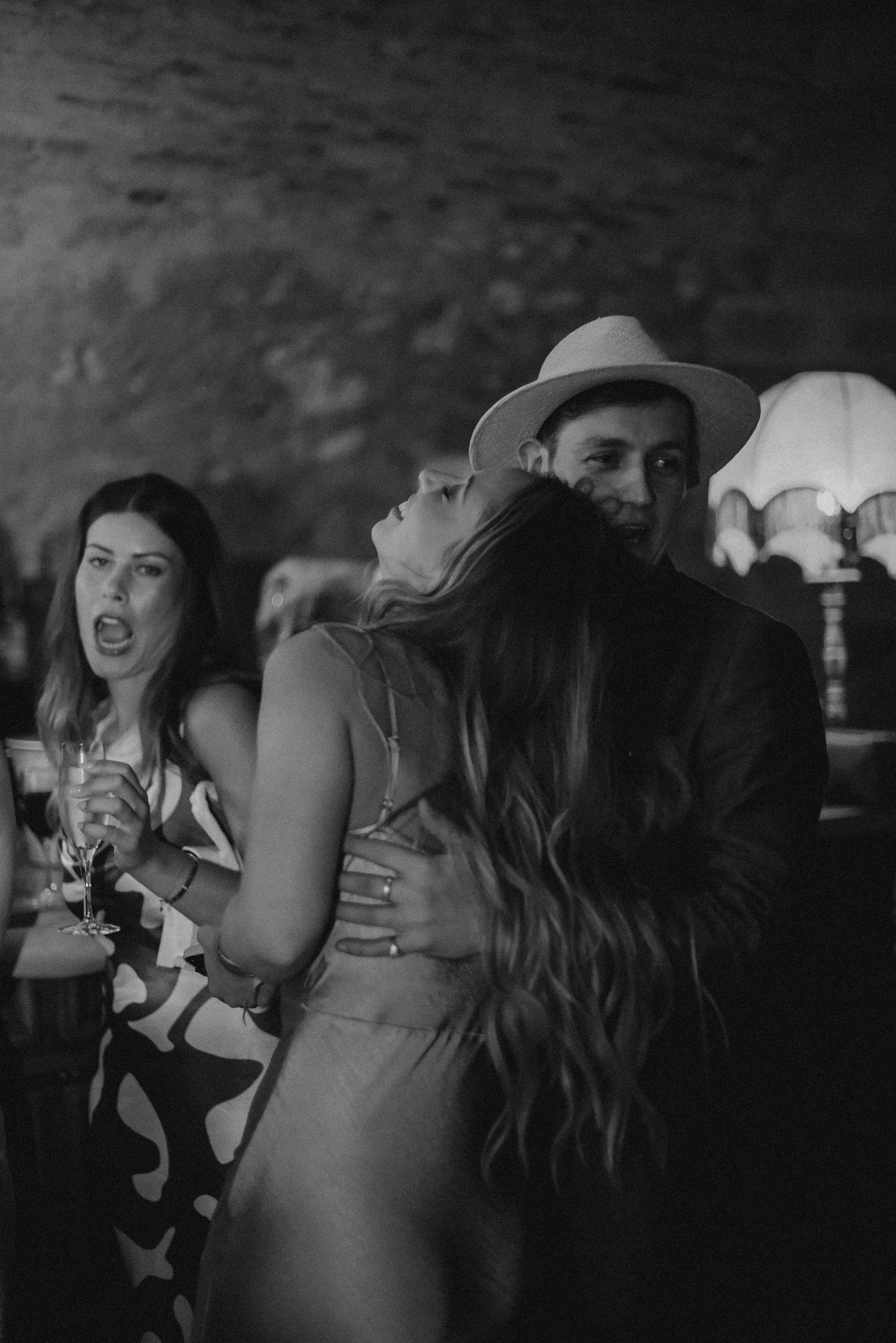 A black and white photo capturing people dancing and enjoying themselves at a party.