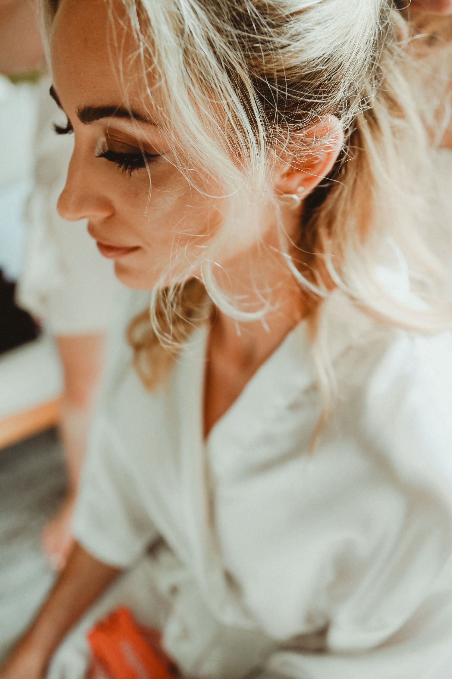 Close-up profile shot of blonde hair styled elegantly with soft lighting and delicate makeup.