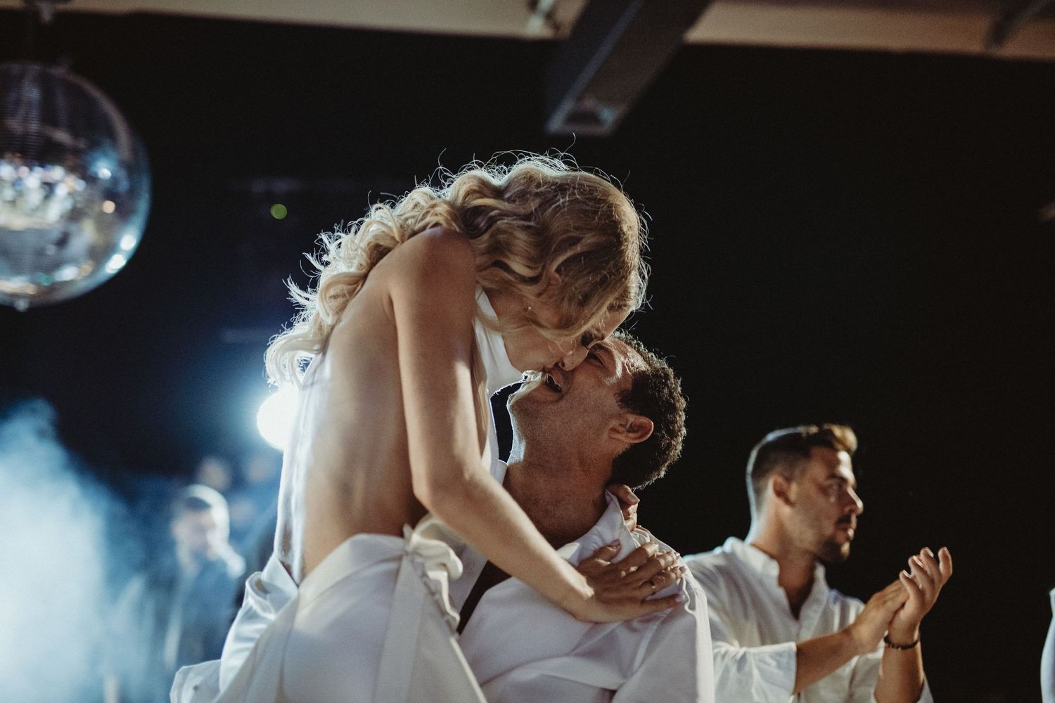 Romantic dance moment at wedding reception with disco lights.