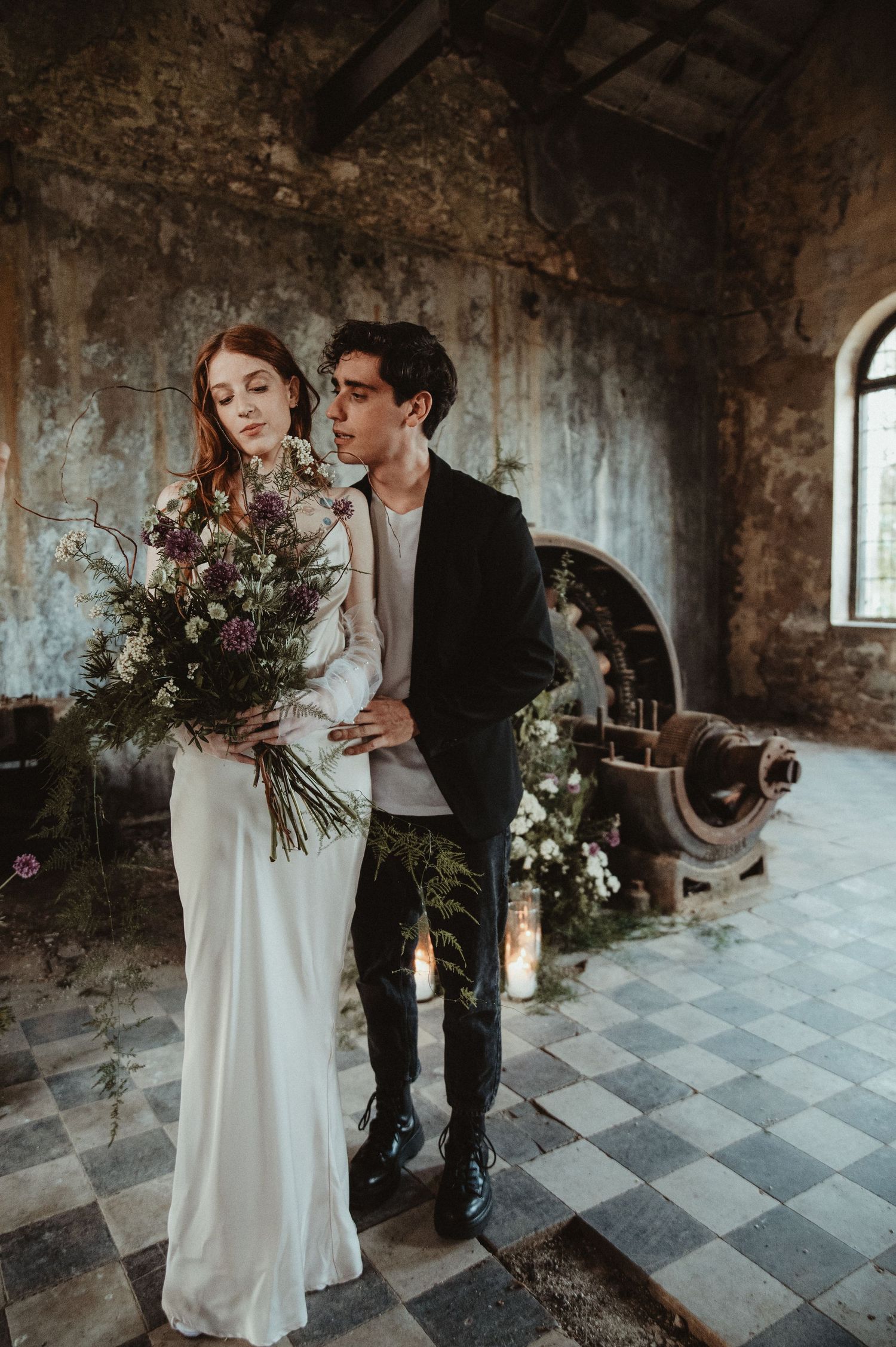 Romantic scene in rustic stone building with checkerboard floor and natural bouquet.